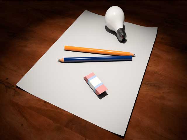Hola de papel, lápiz, bombilla encima de una mesa