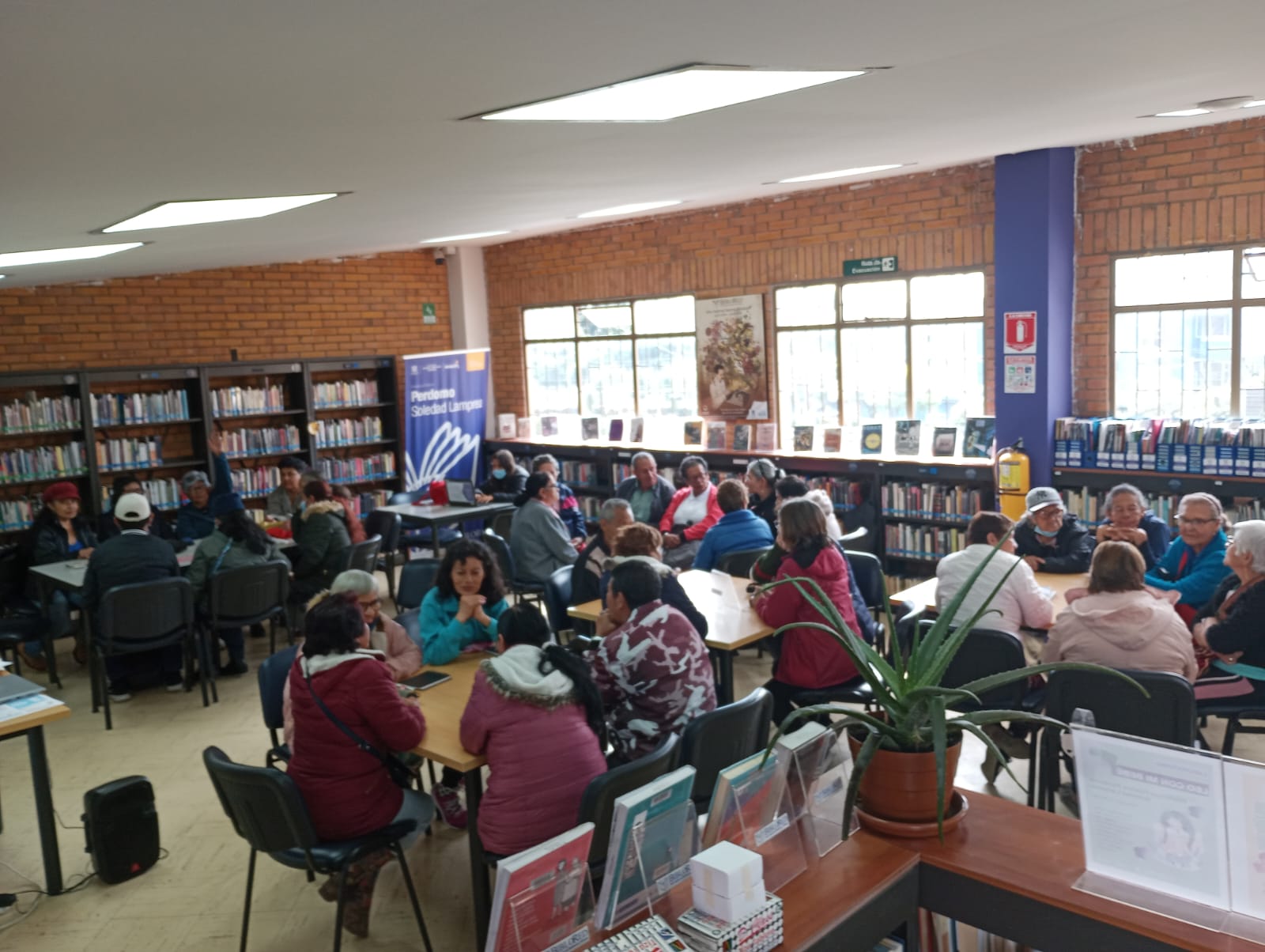 Personas leyendo y hablando en la biblioteca