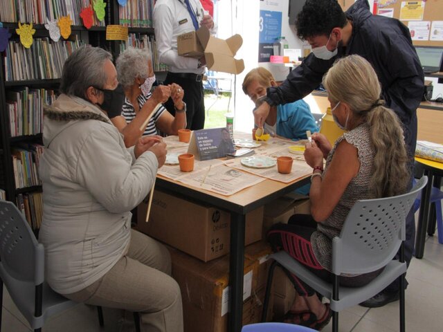 personas mayores tejiendo reunidas en la biblioteca