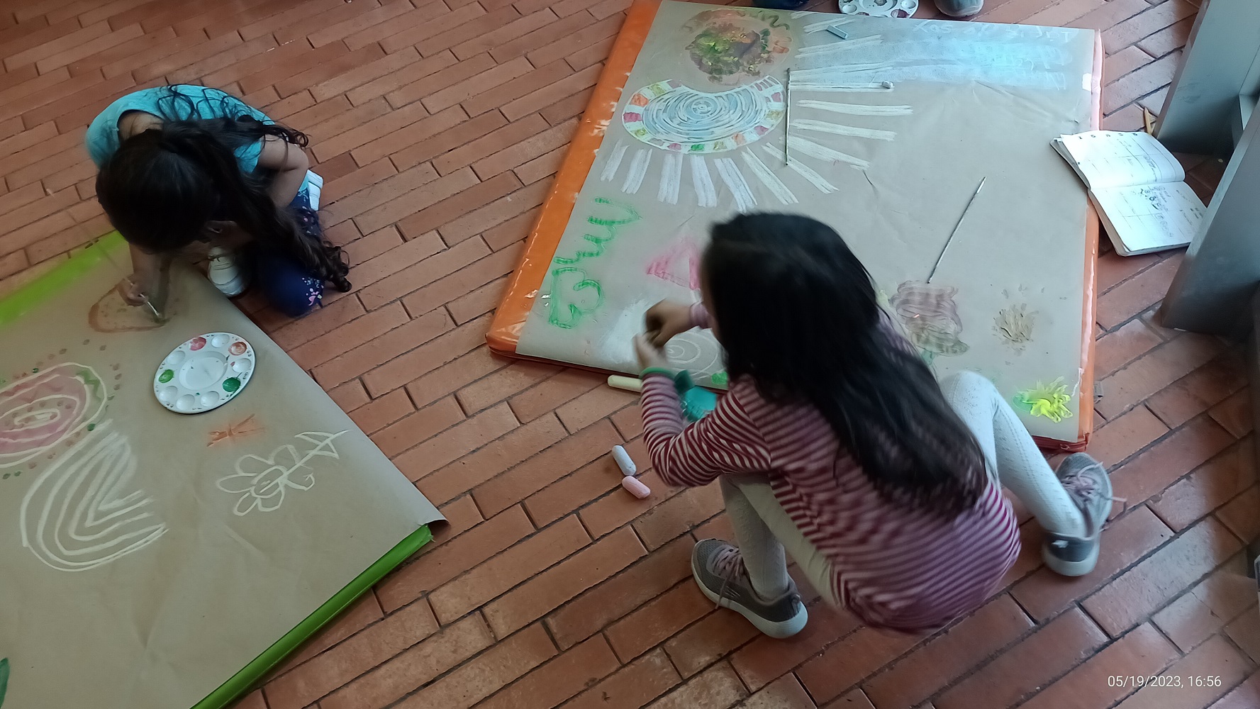 niñas pintando paisajes en papel