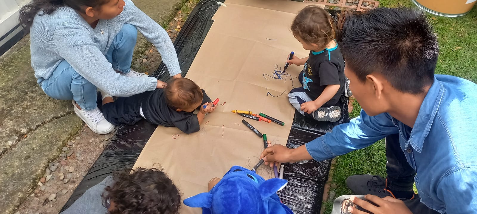 bebés rayando un papel con crayolas 