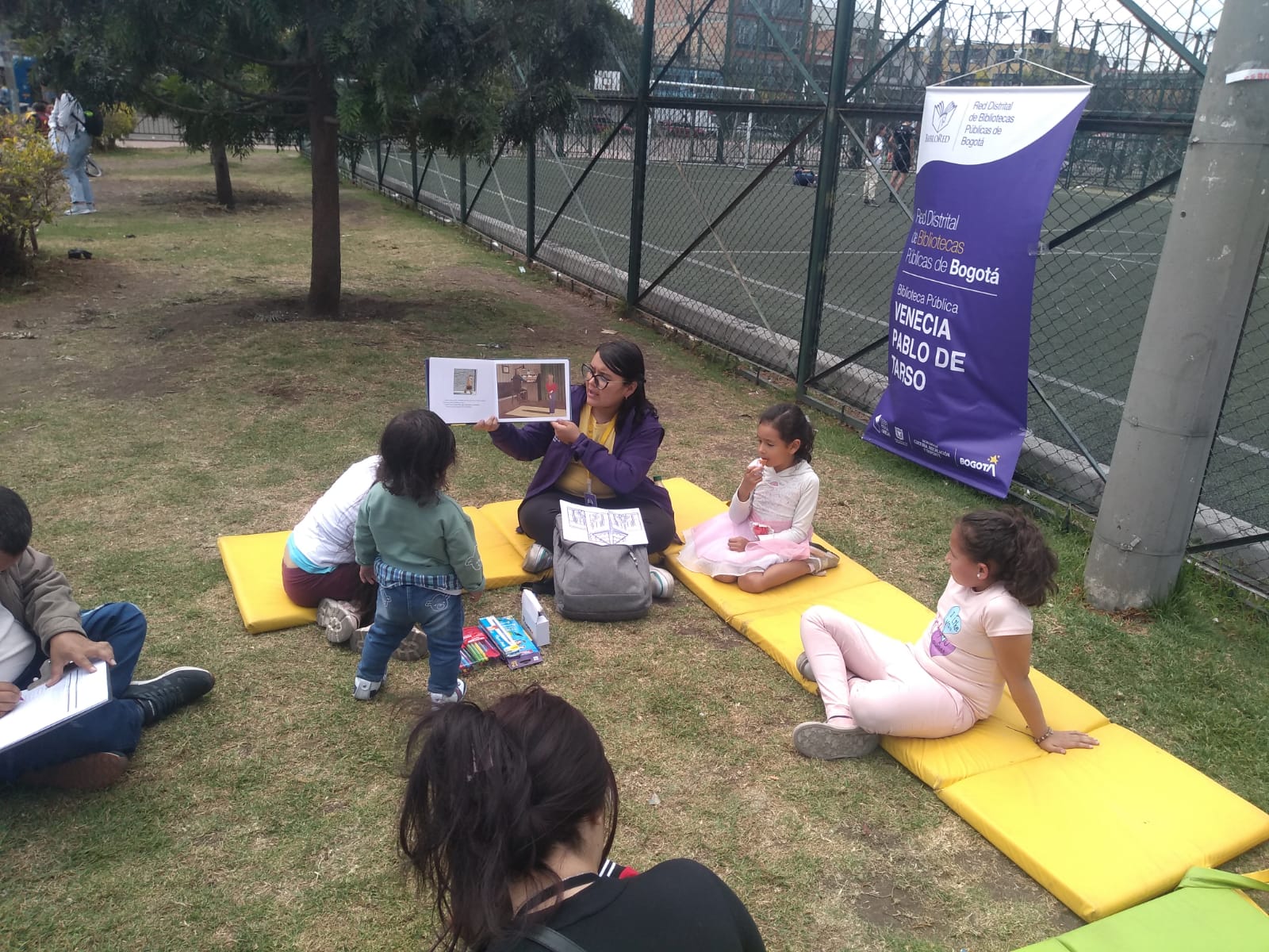 lectura en voz alta en un parque para niñas y niños
