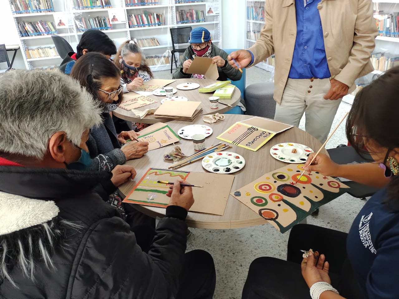 grupo de adultos mayores en medio de un curso de manualidades y pintura