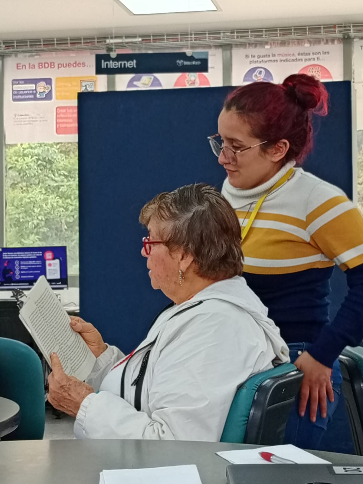 una mujer mayor leyendo junto a una mujer