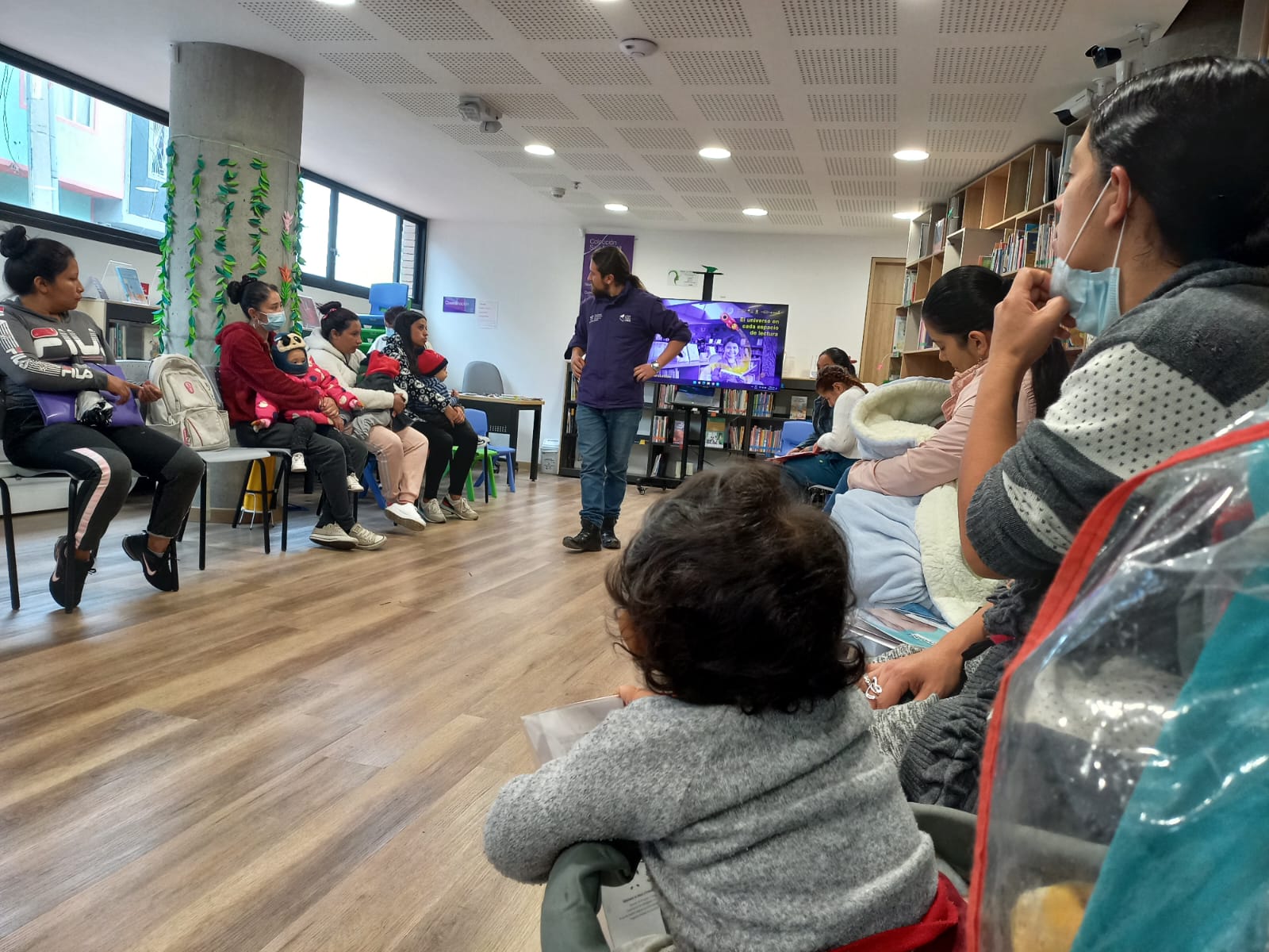 Bebés y adultos participan de actividad en la biblioteca