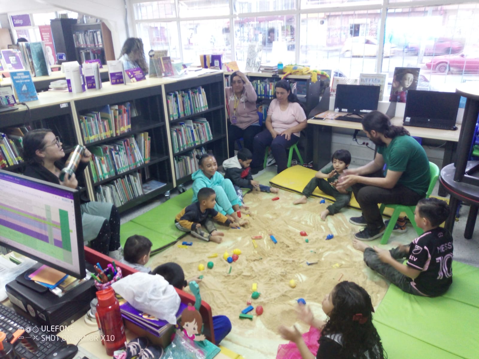 Bebés y adultos participando de actividad en la biblioteca