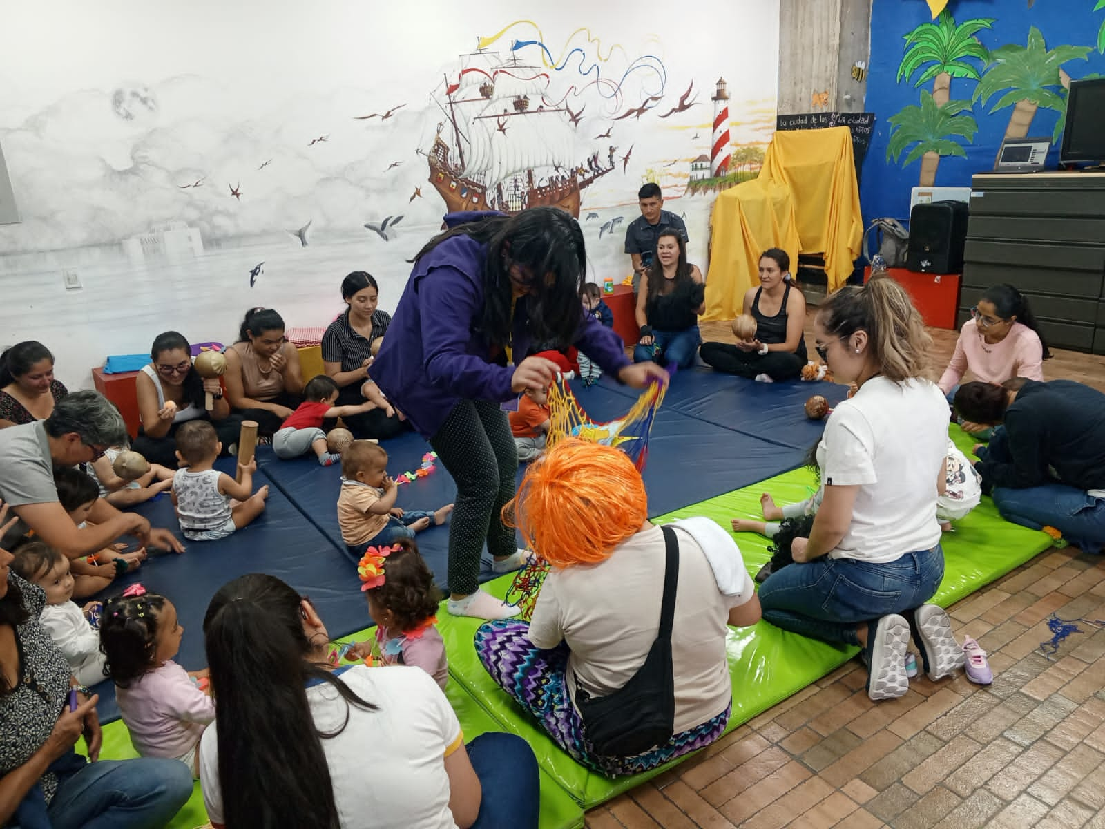 Familias junto a sus bebés participando de experiencias lúdicas en la biblioteca