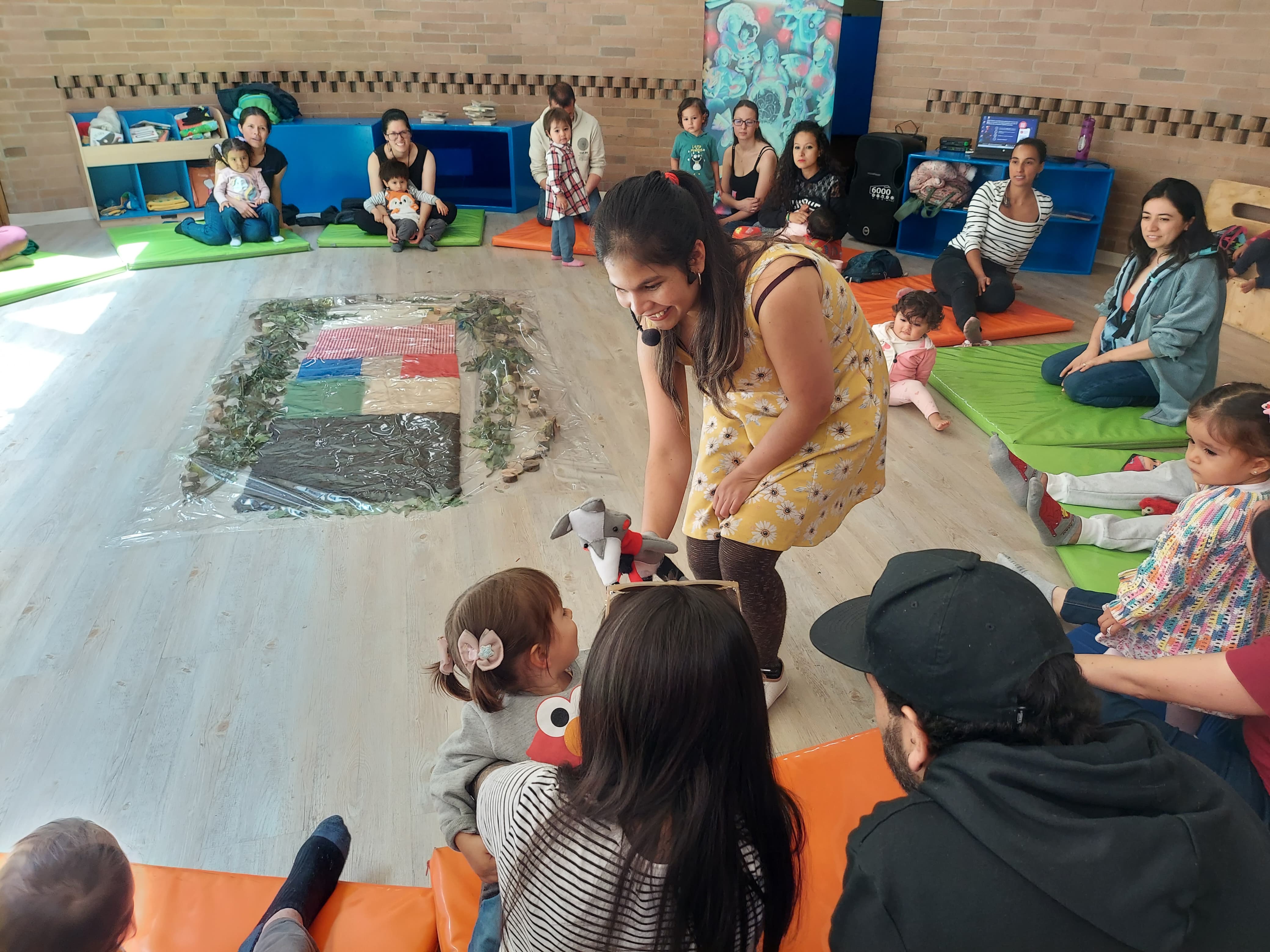 grupo de niños jugando con su profesora y unos títeres 