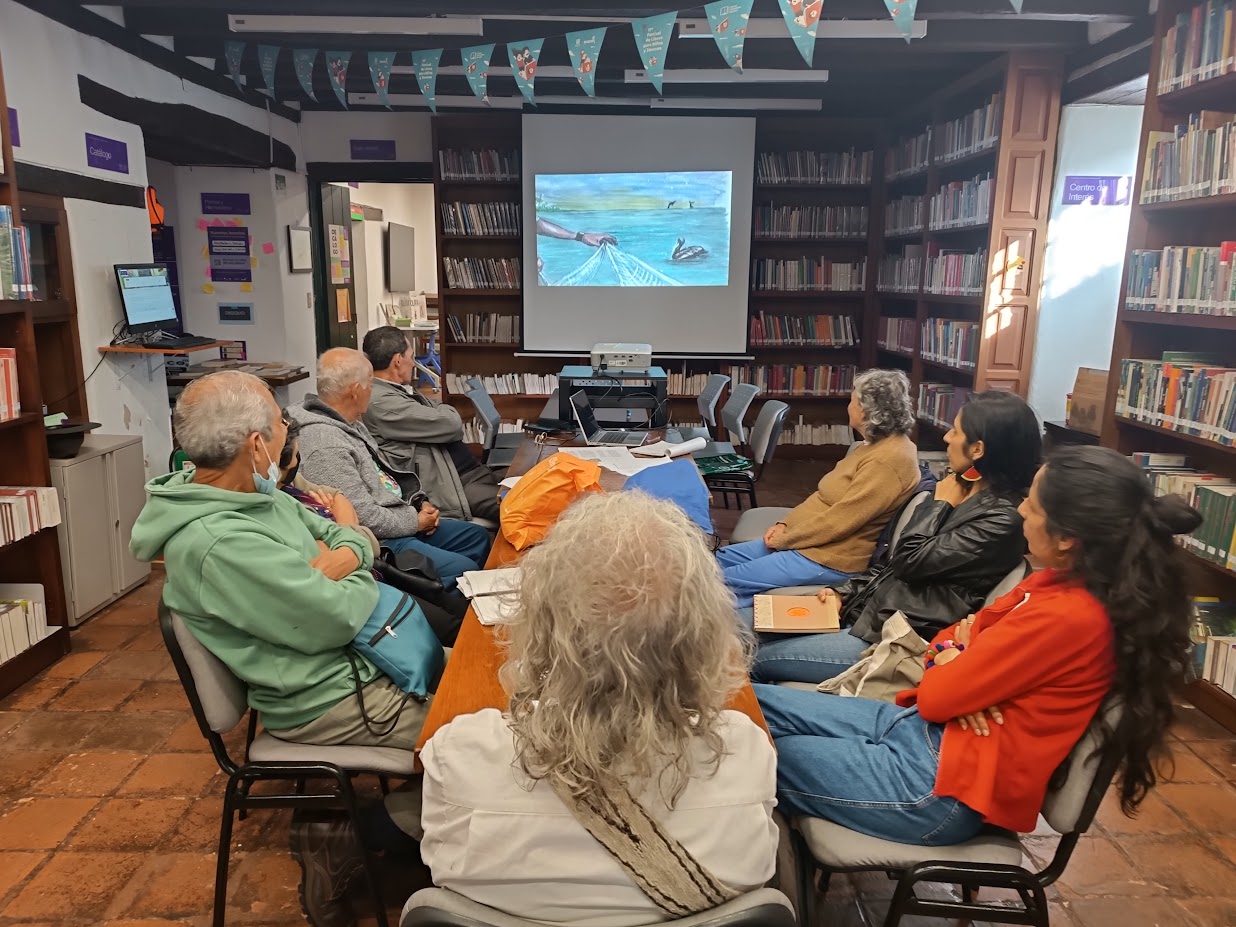 Adultos mayores participando en el club de lectura en la biblioteca