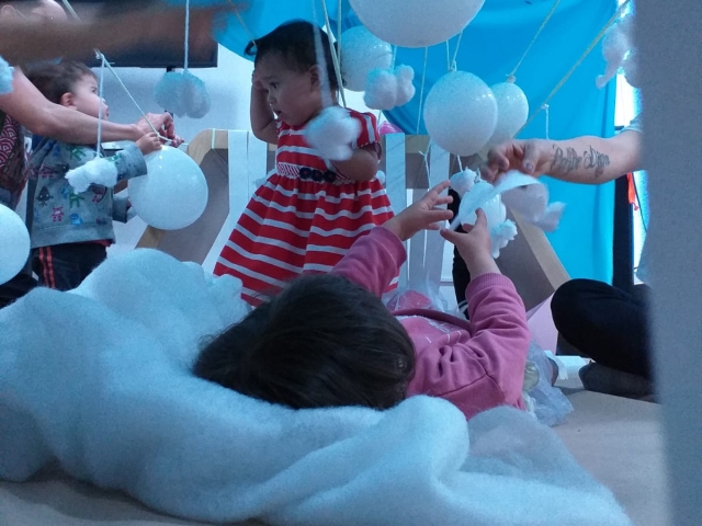 Infancia y sus cuidadores participando de experiencias sensoriales y lúdicas en la biblioteca