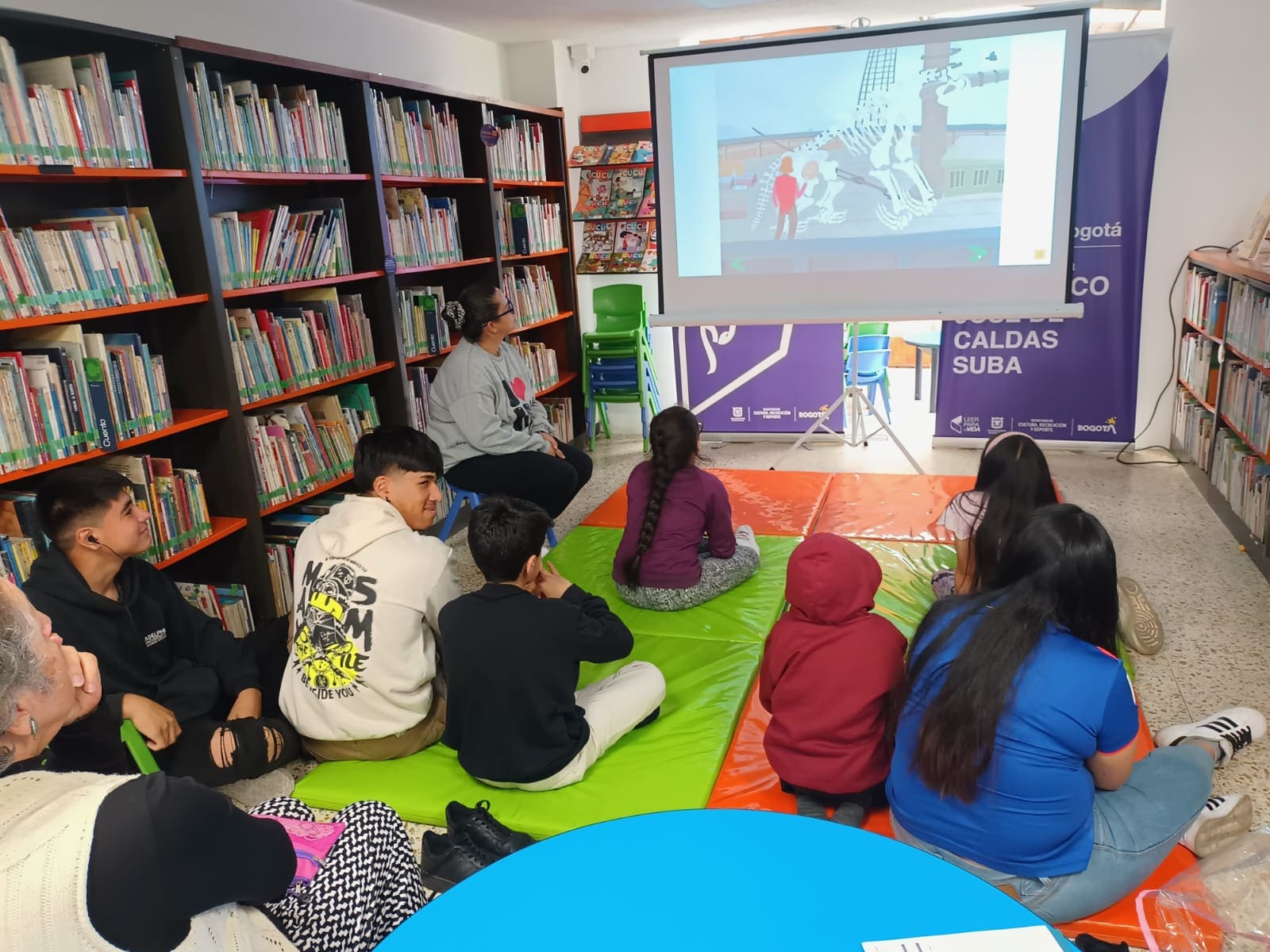 niños y niñas frente a un proyector disfrutando de una película