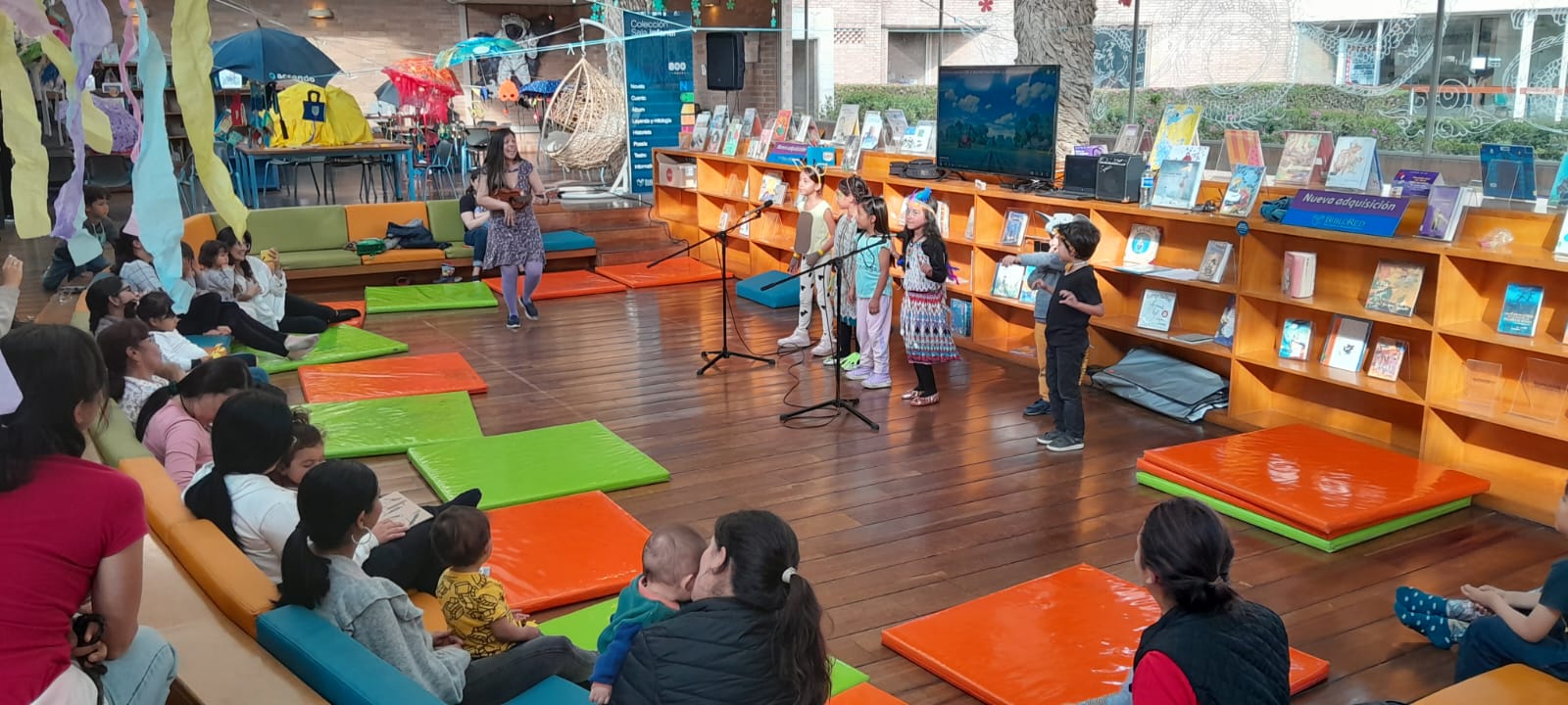 Infancia y sus cuidadores disfrutando de actividades en la biblioteca