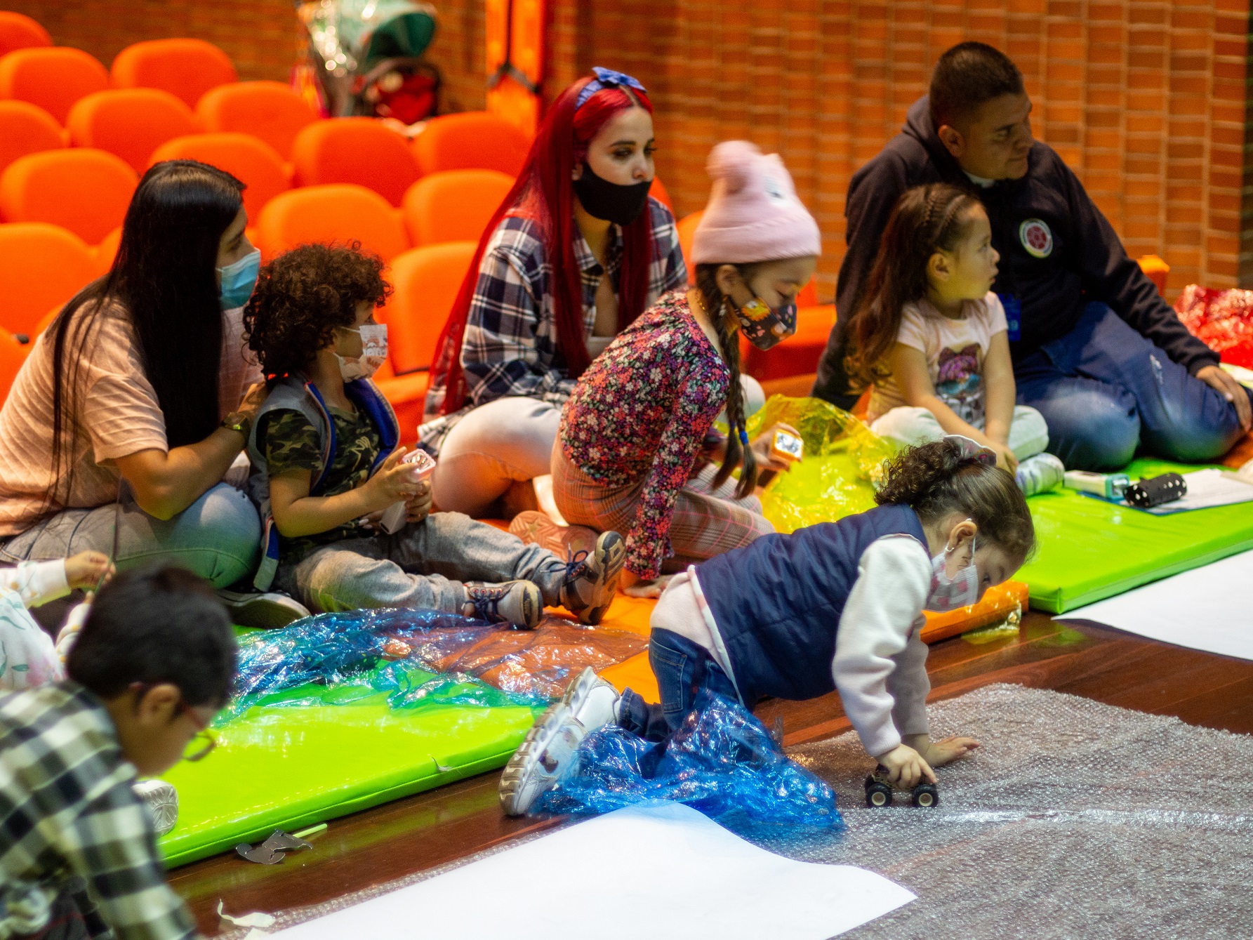 Infancias y sus cuidadores participando de actividades lúdicas y sensoriales en la biblioteca