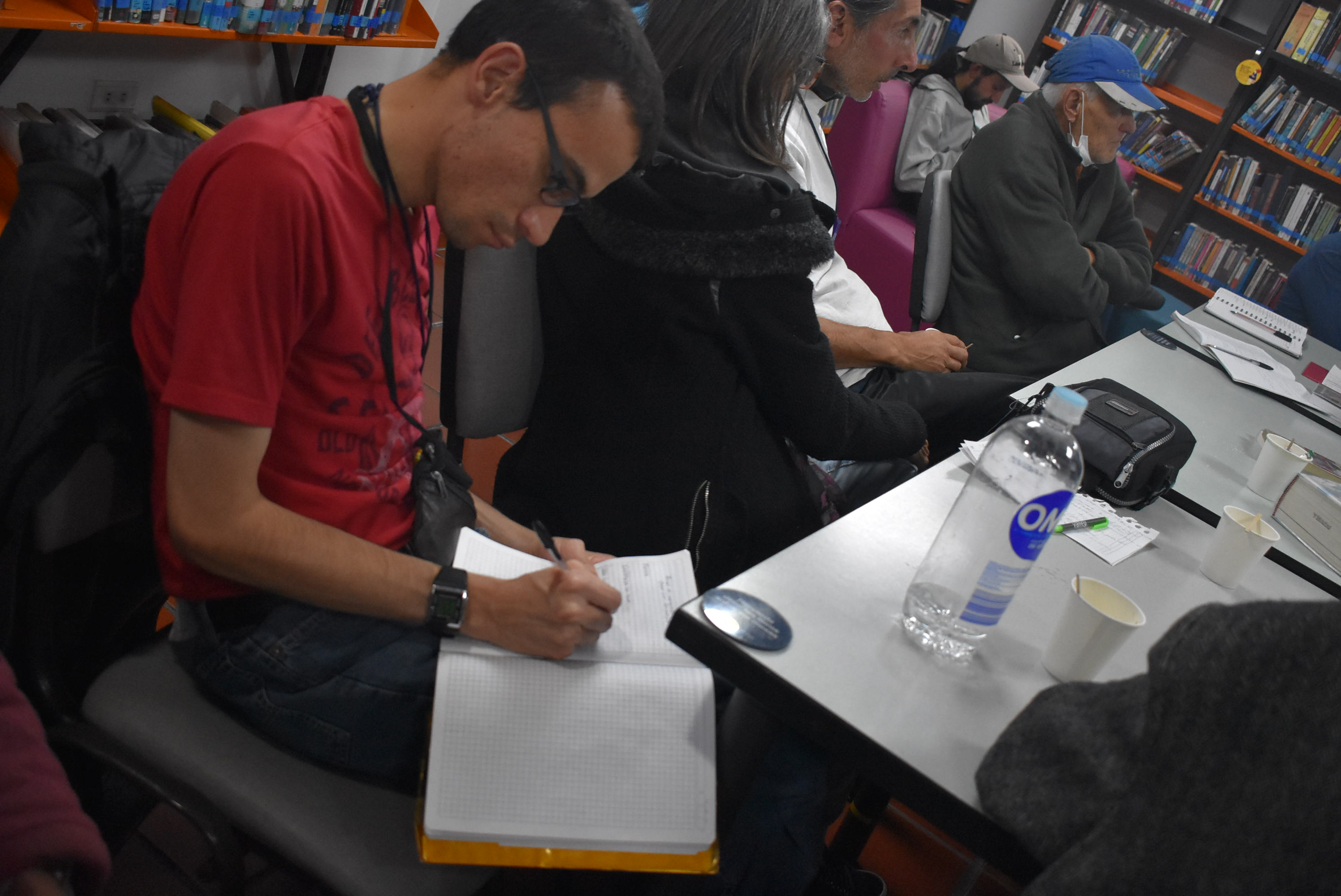 Adulto escribiendo en actividad de la biblioteca