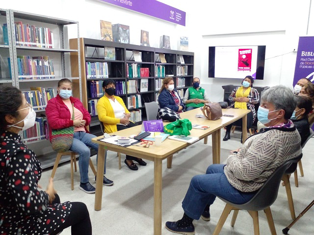 Personas participando en el club de ficción en la biblioteca