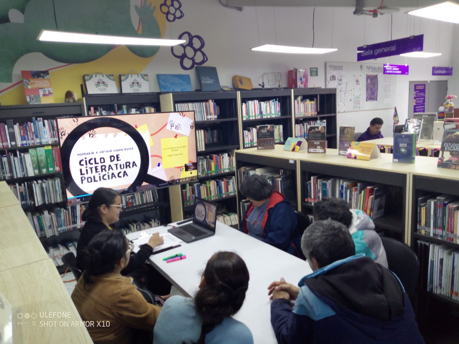 Personas participando en el club de lectura en la biblioteca