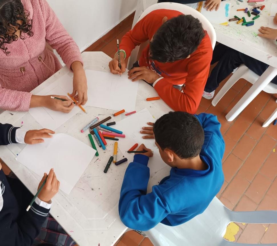 Adultos y niños colorean en actividad de biblioteca