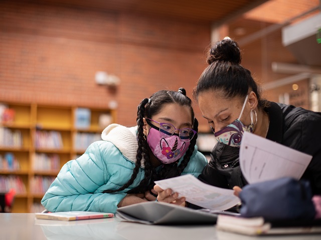 niña y su madre leyendo un libro juntas 