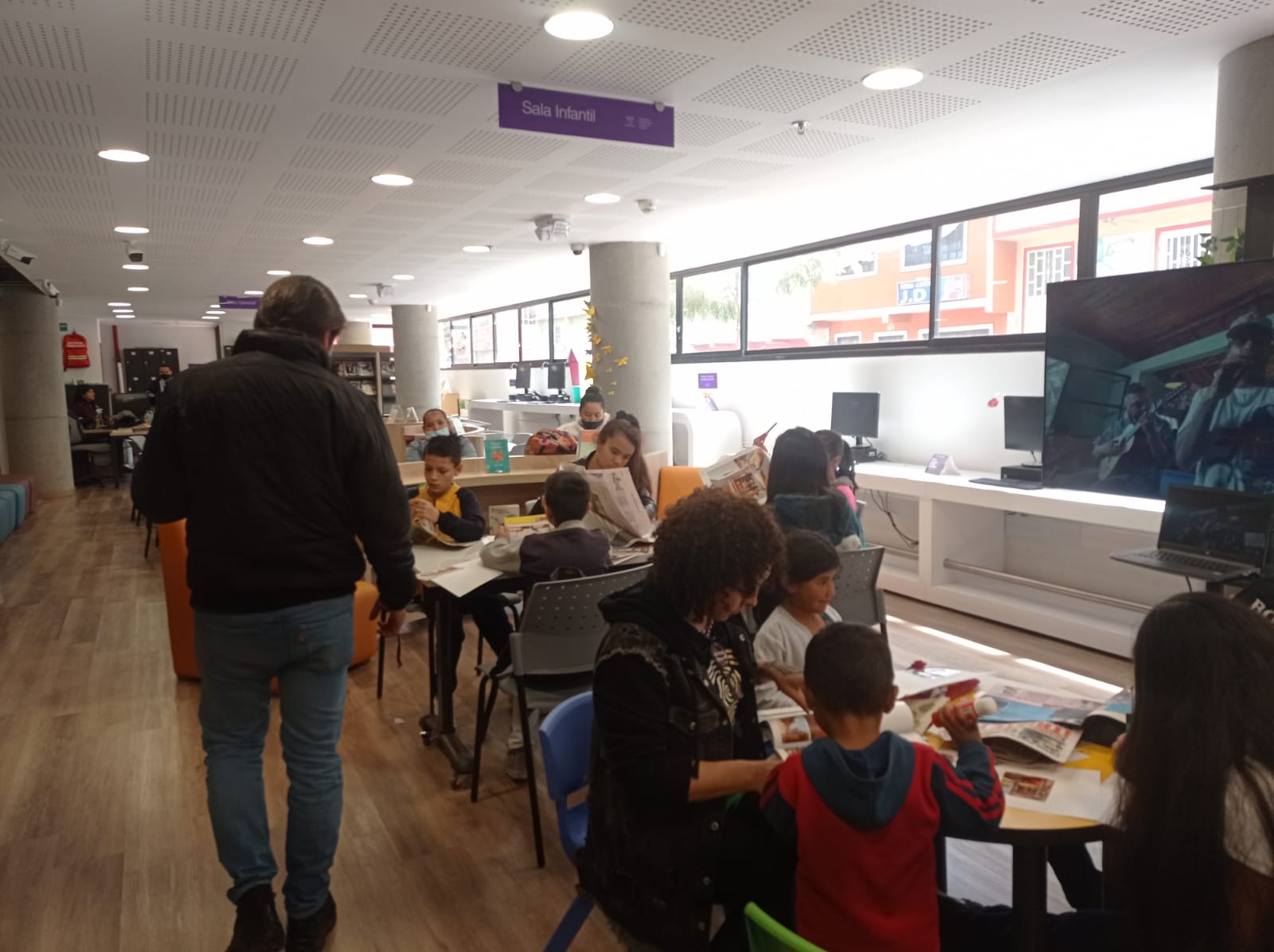 grupo de niños y niñas acompañados de sus padres en un taller de manualidades