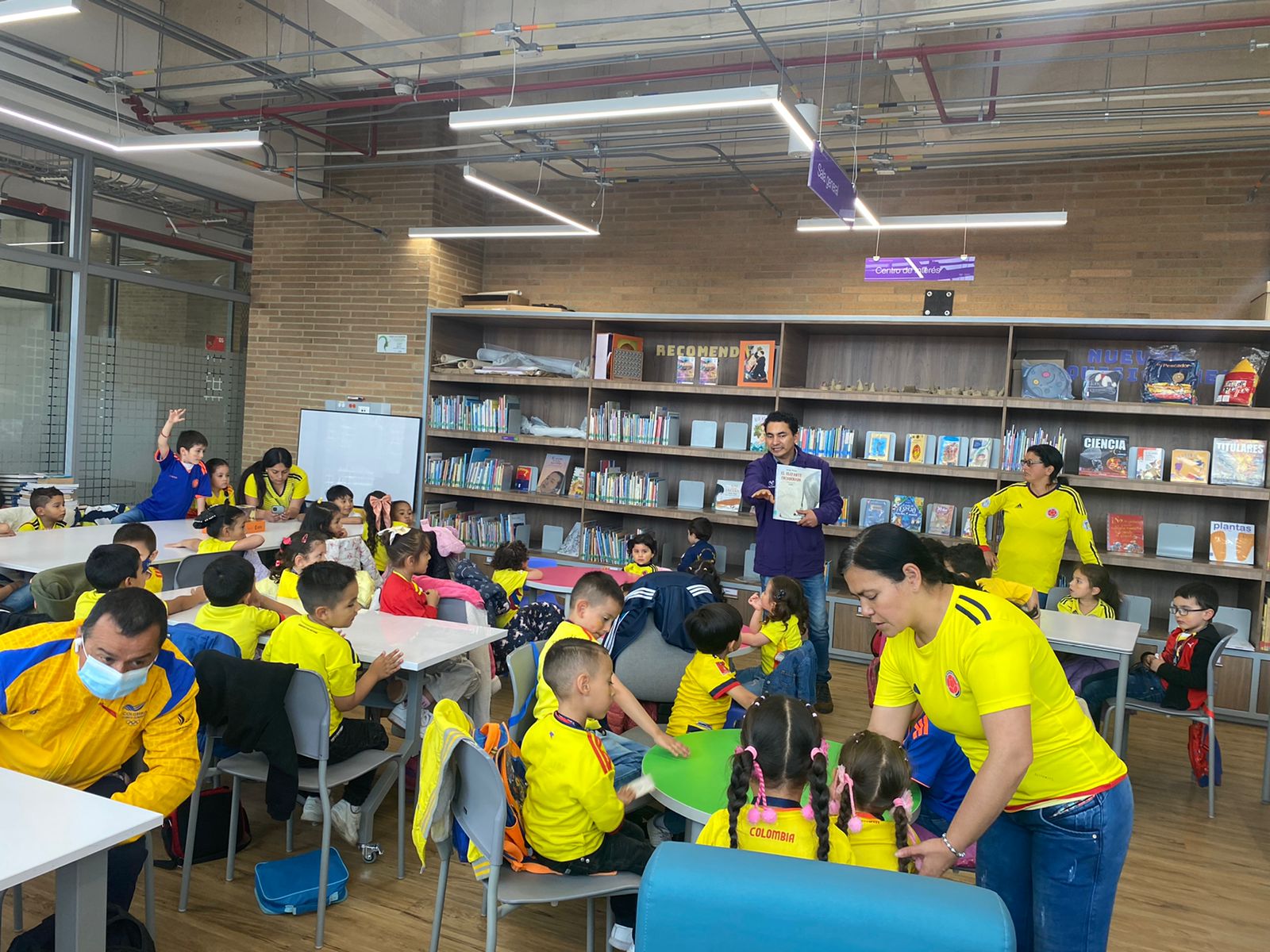 Infancias participando en el club de lectura infantil en la biblioteca