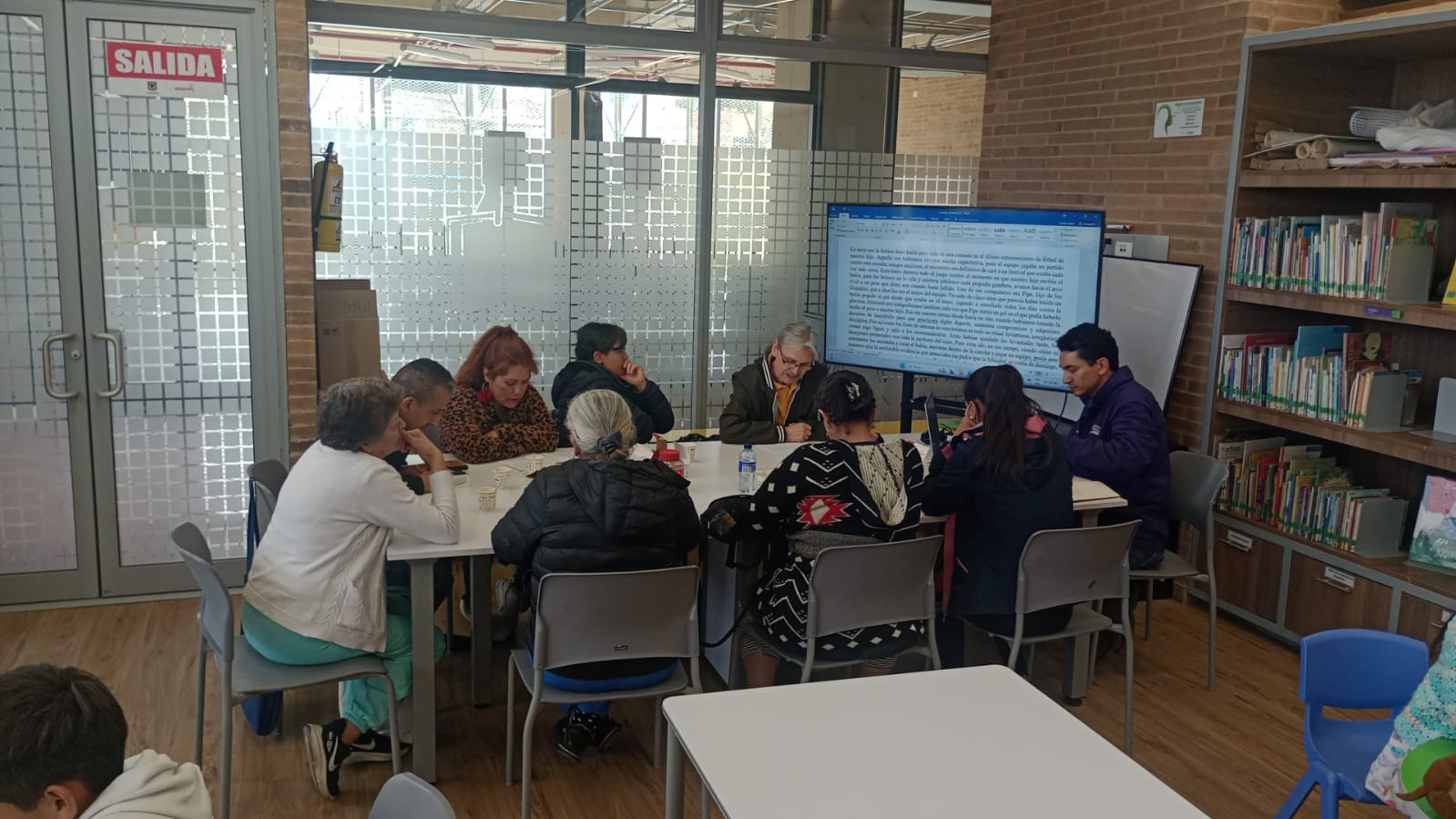 grupo de adultos dialogando sobre una presentación 