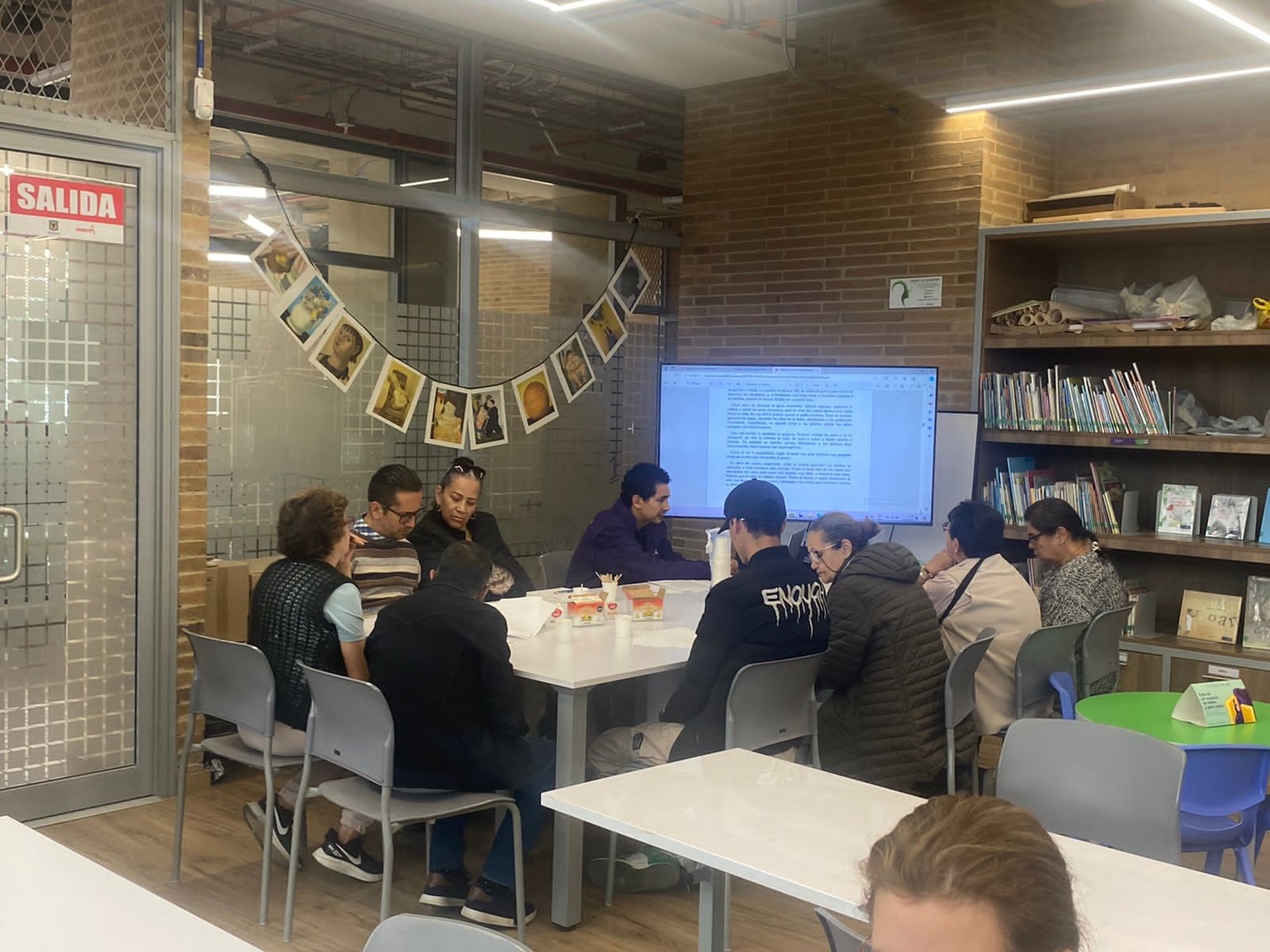 grupo de adultos mayores dialogando en medio de una sala de la biblioteca