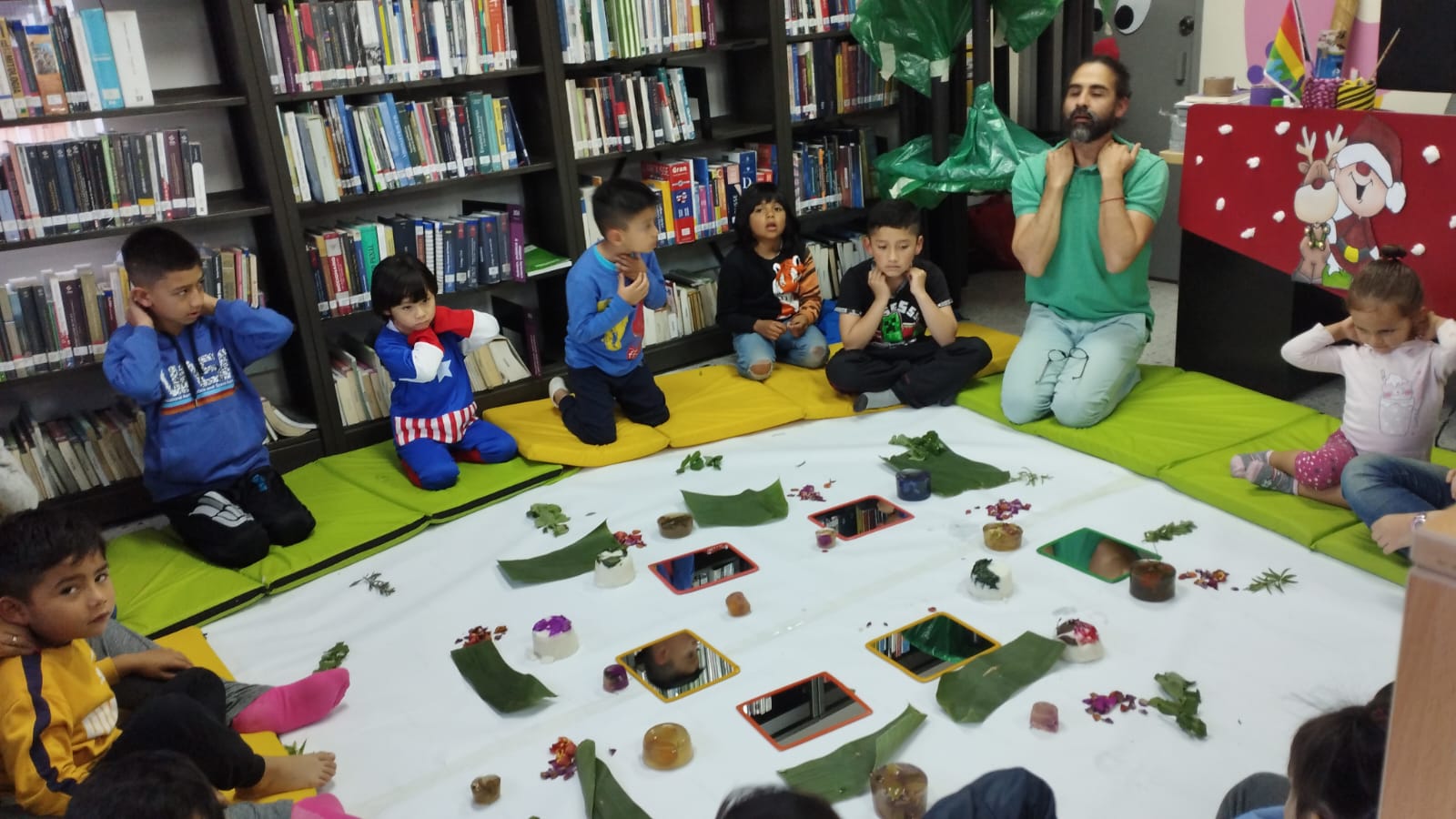 Infancias junto a sus familias participando en experiencias lúdicas en la biblioteca