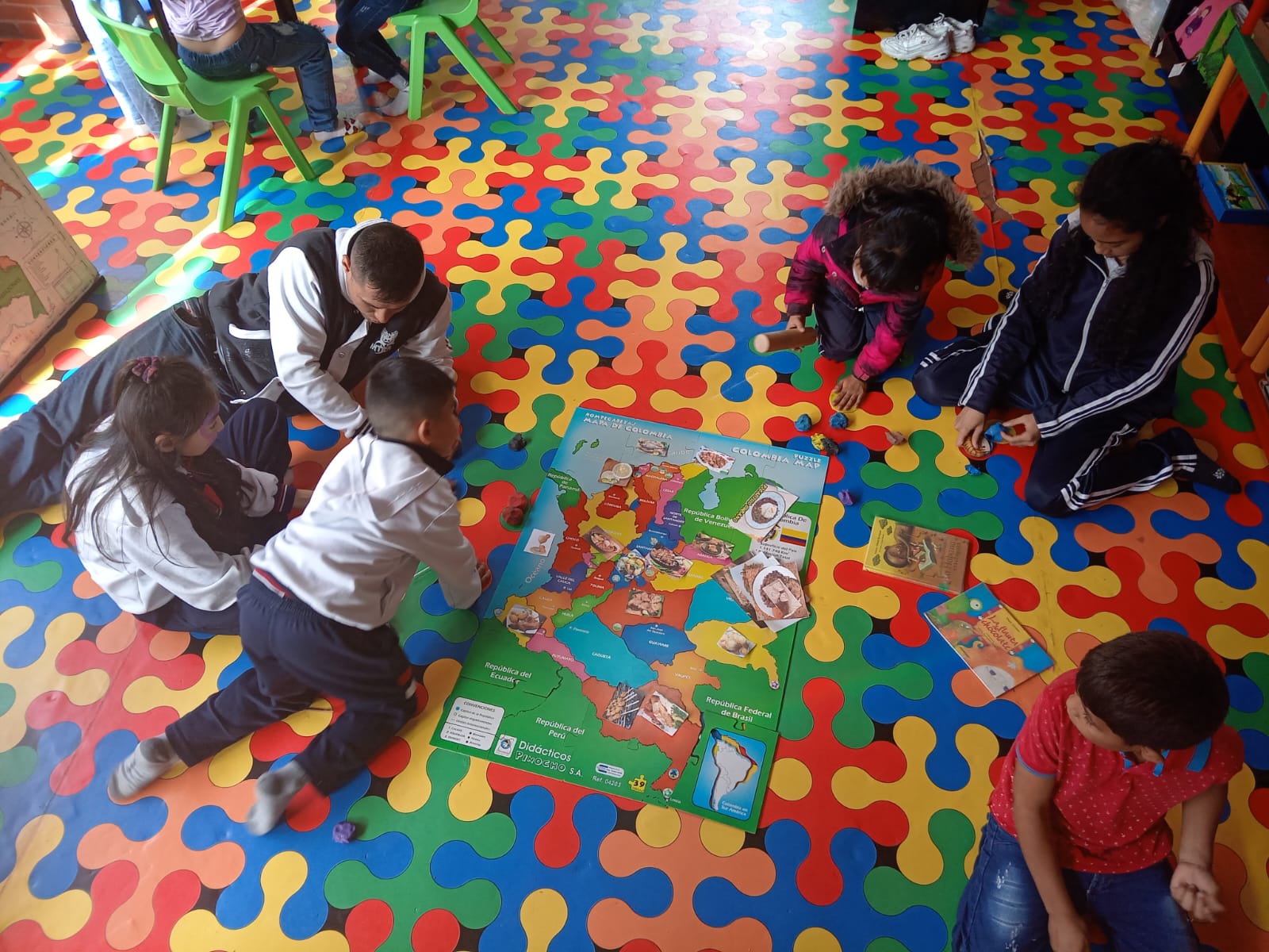 Cuidadores y niños participando en experiencias lúdicas en la sala infantil de la biblioteca