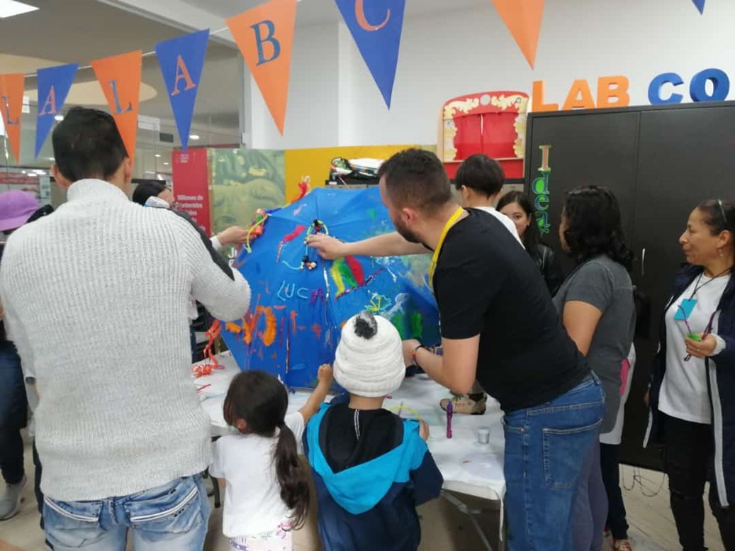 Niños y cuidadores pintando una obra artística