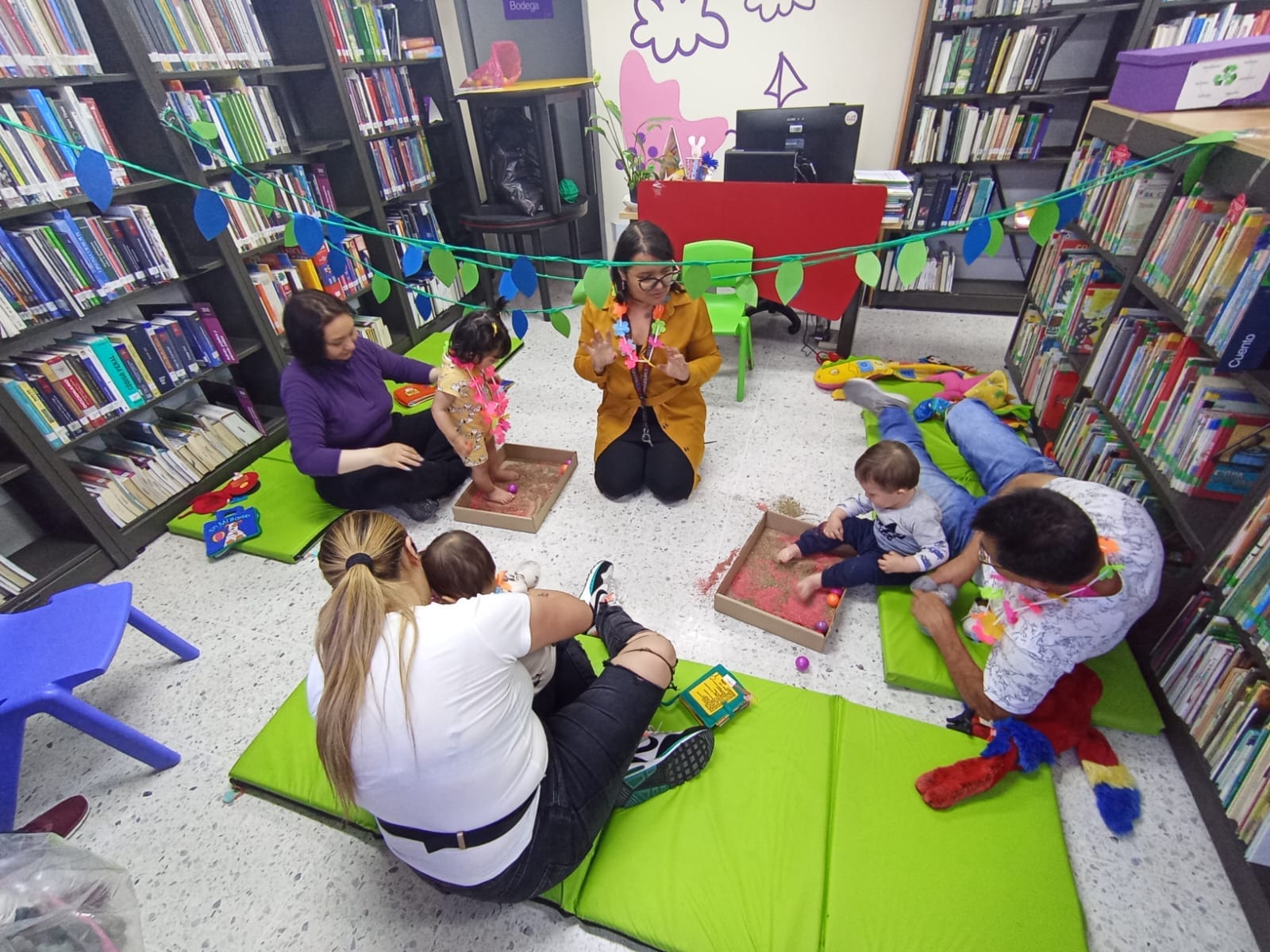 grupo de bebés junto a sus padres jugando