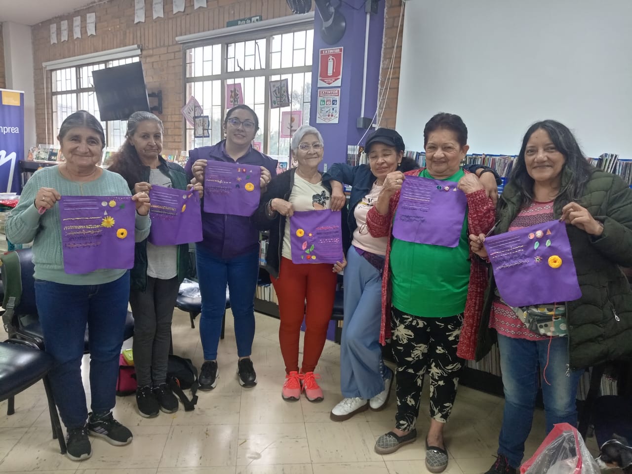 grupo de mujeres mostrando lo que tejieron durante el taller de manualidades