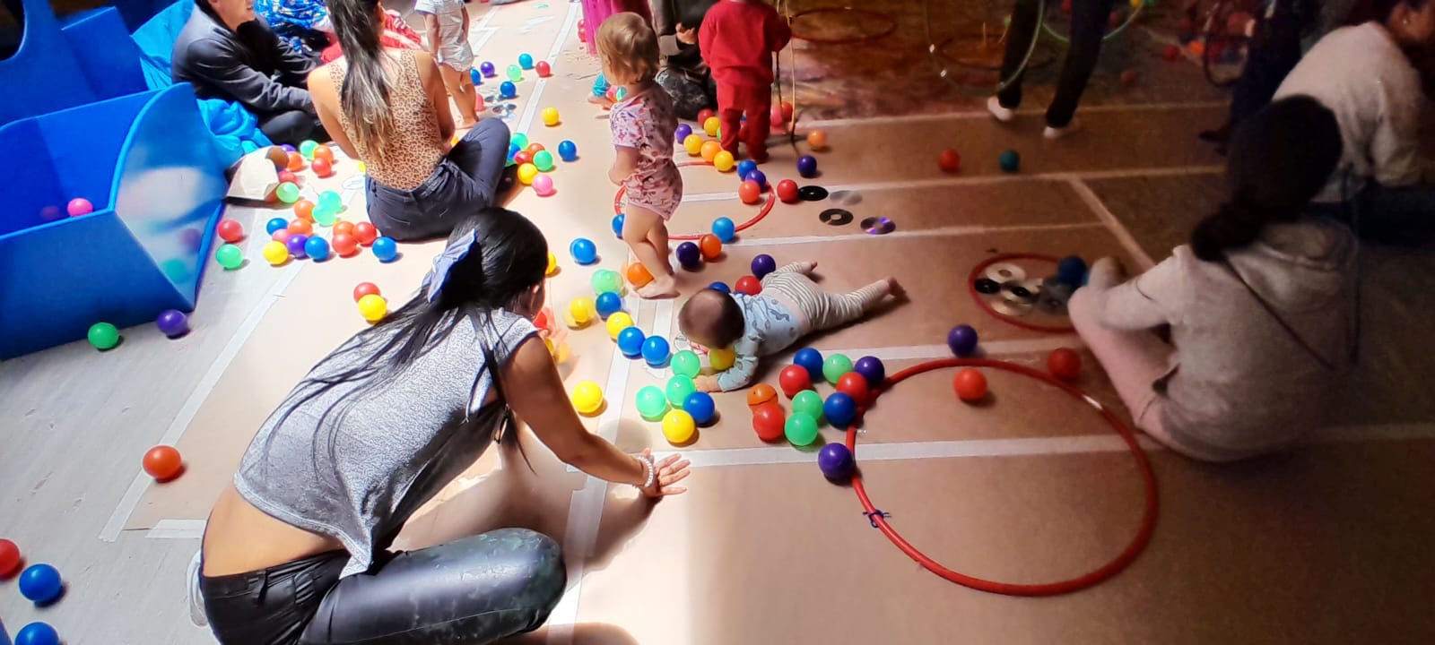 Infancias y sus cuidadores participando en experiencias lúdicas y artísticas en la biblioteca