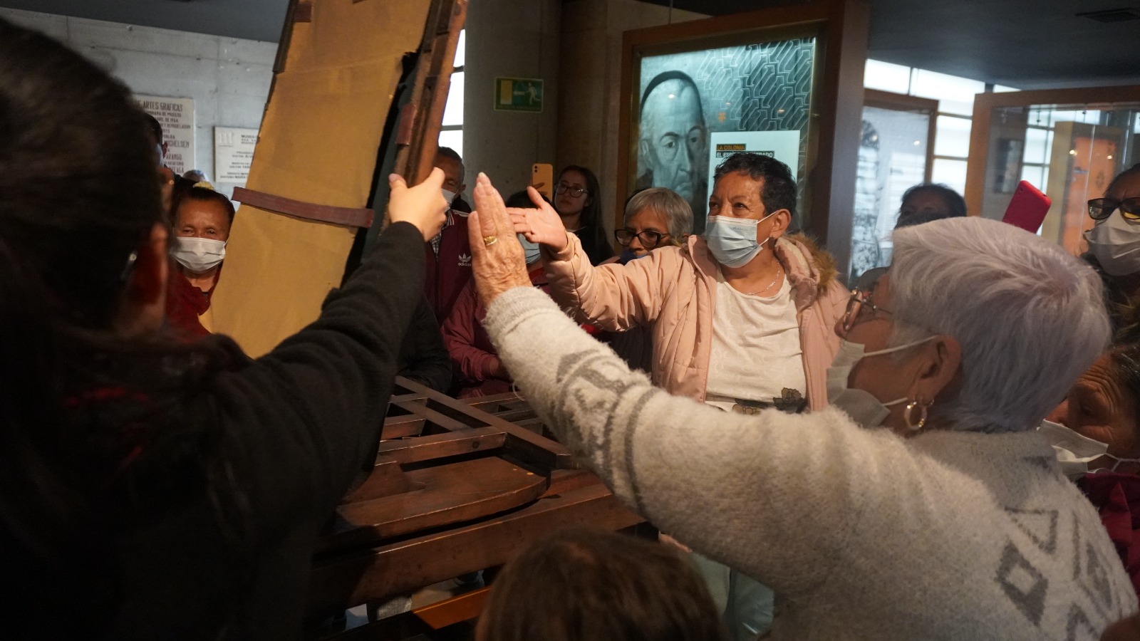 Grupo de mujeres mayores interactuándo con una exposición en un museo 