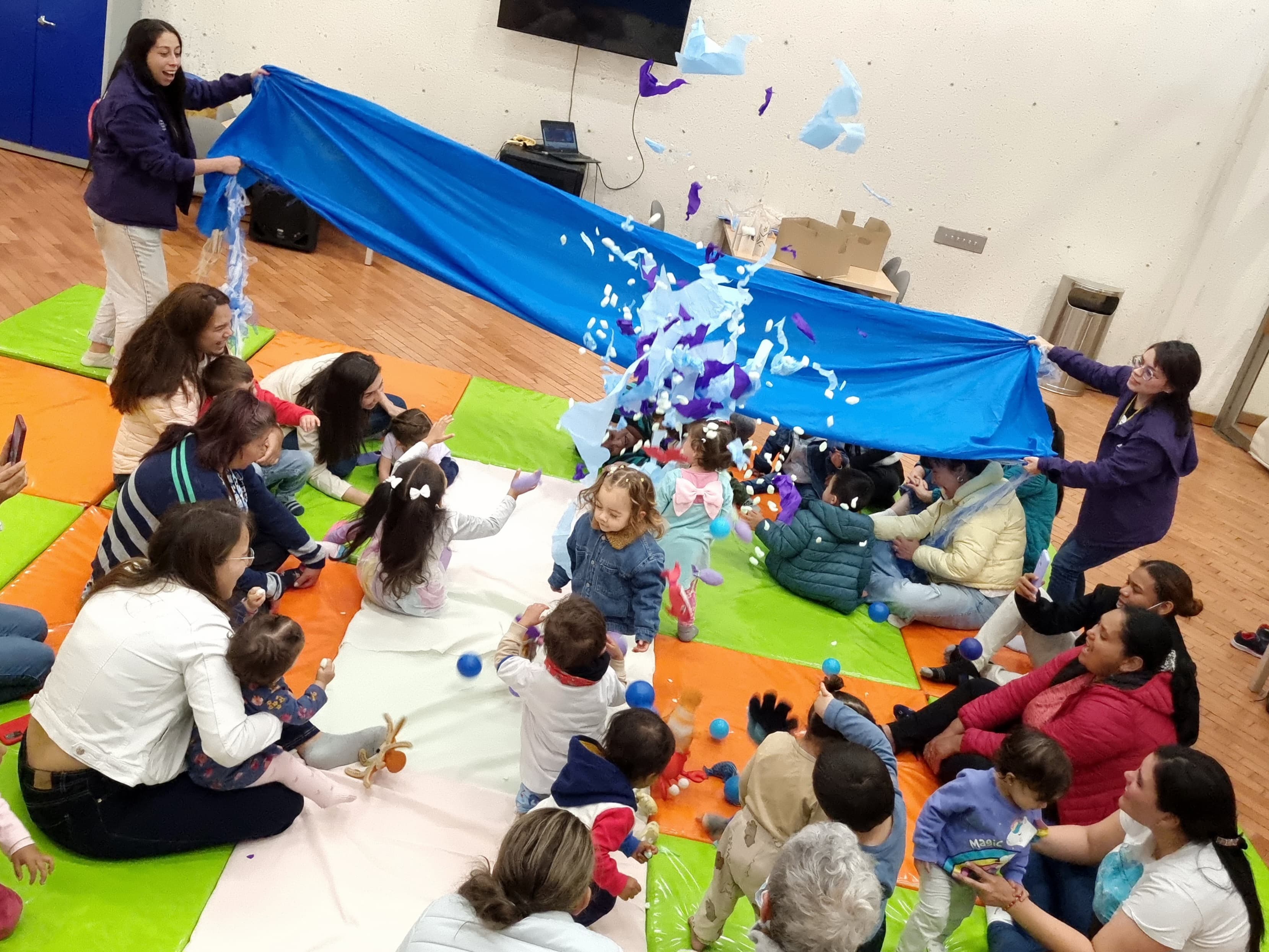 grupo de niños y niñas jugando con papeles de colores