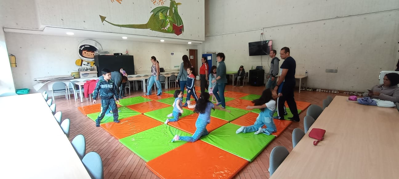 grupo de niñas en medio de un taller haciendo yoga