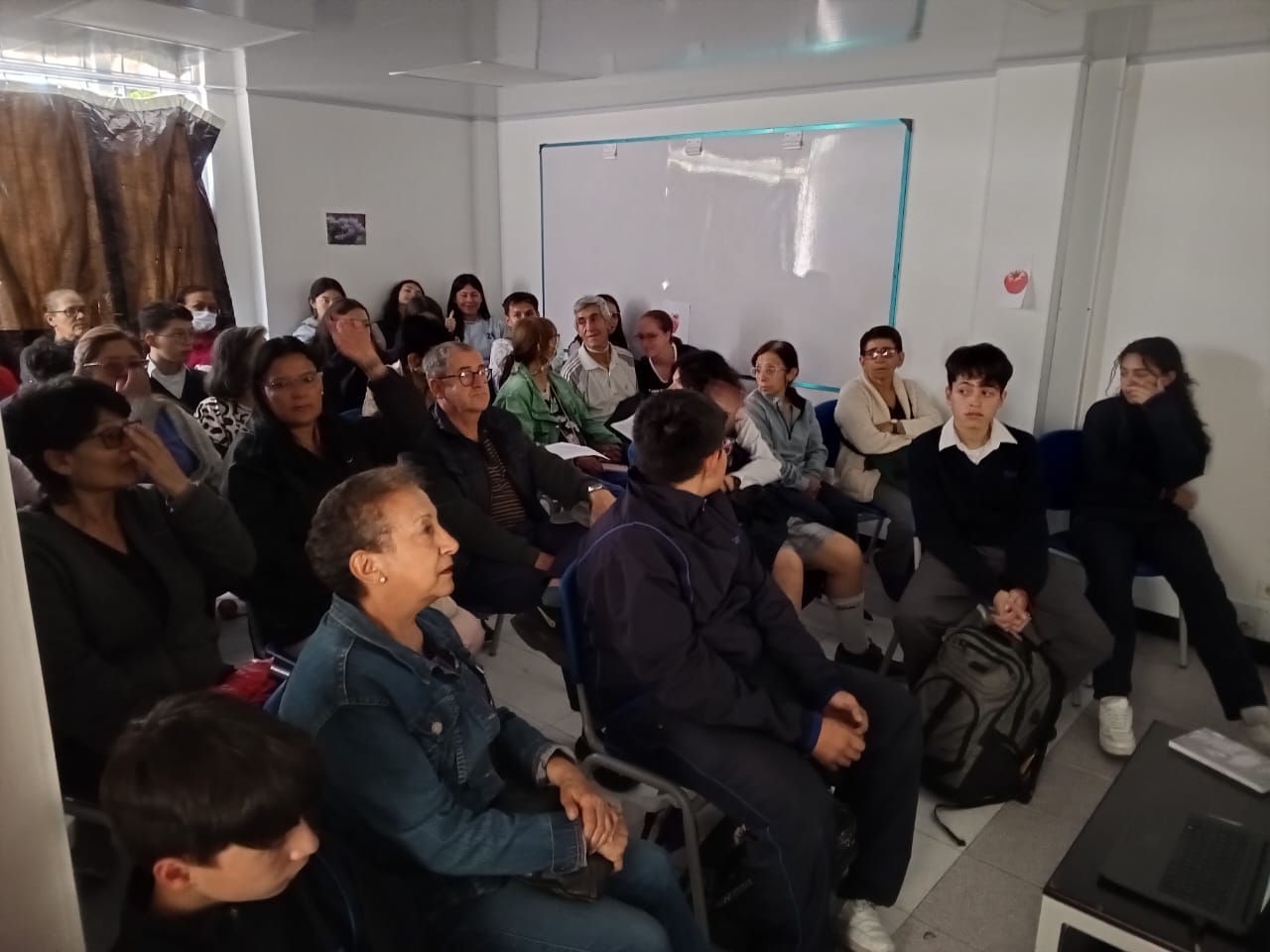 grupo de adultos mayores en medio de una sala esperando que inicie la proyección de una película