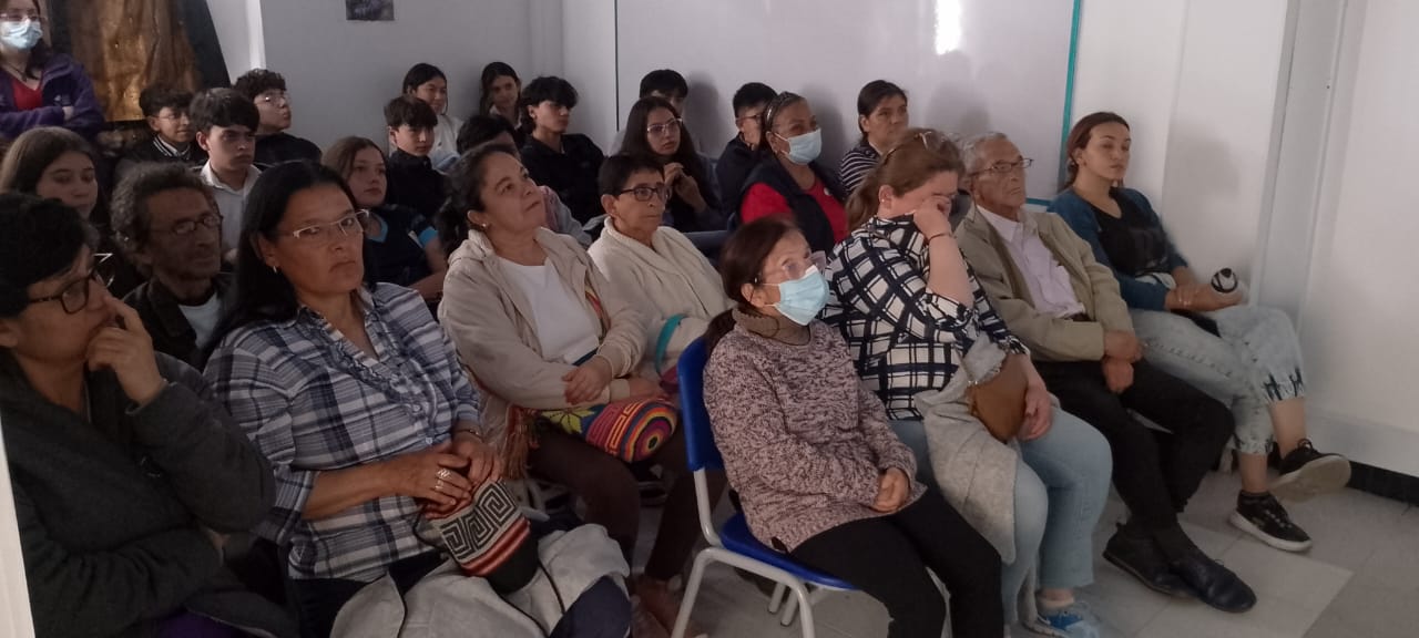 grupo de adultos mayores esperando que inicie la proyección de una película 