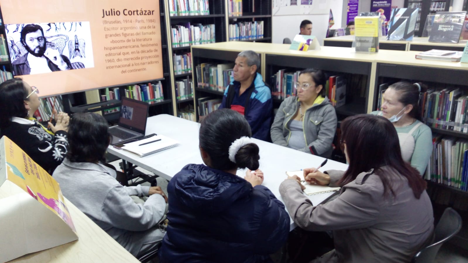 Personas en la biblioteca participando en el club de lectura