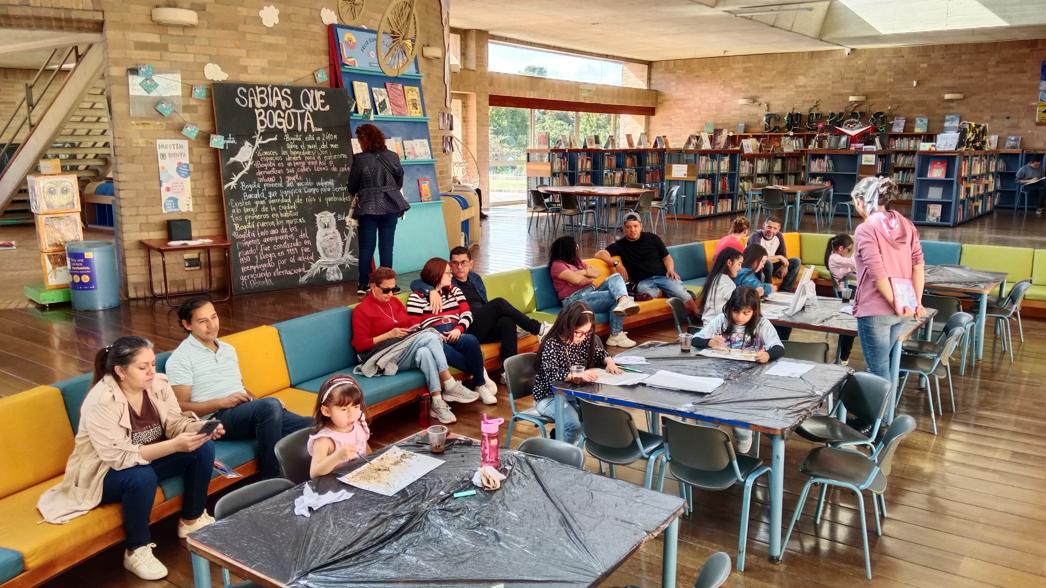 grupo de personas reunidas en medio de una sala de biblioteca 