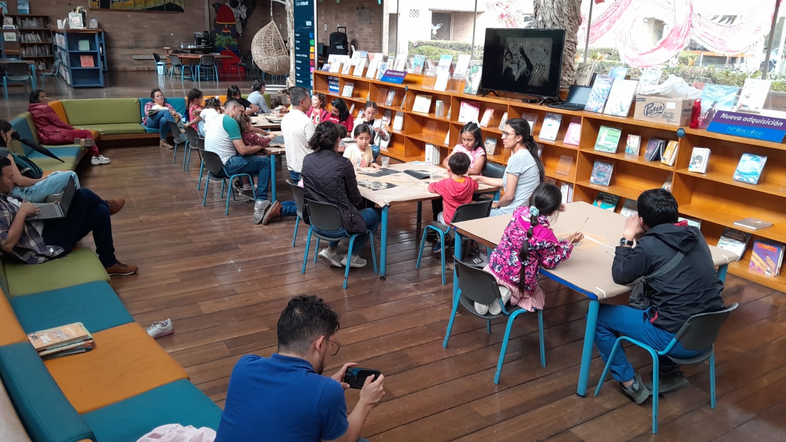 grupo de niños y niñas leyendo junto a sus padres 