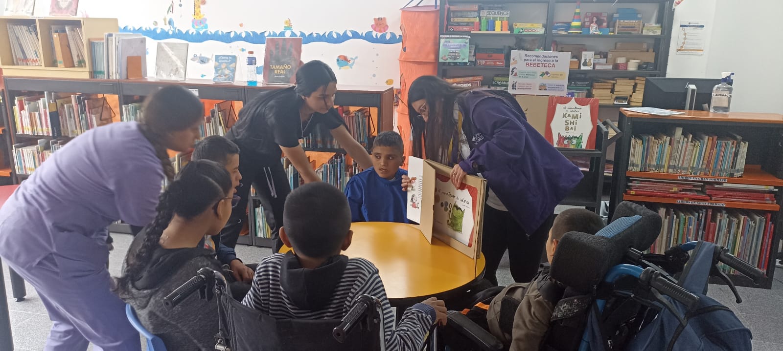 grupo de niños prestando atención a la lectura que realiza la docente