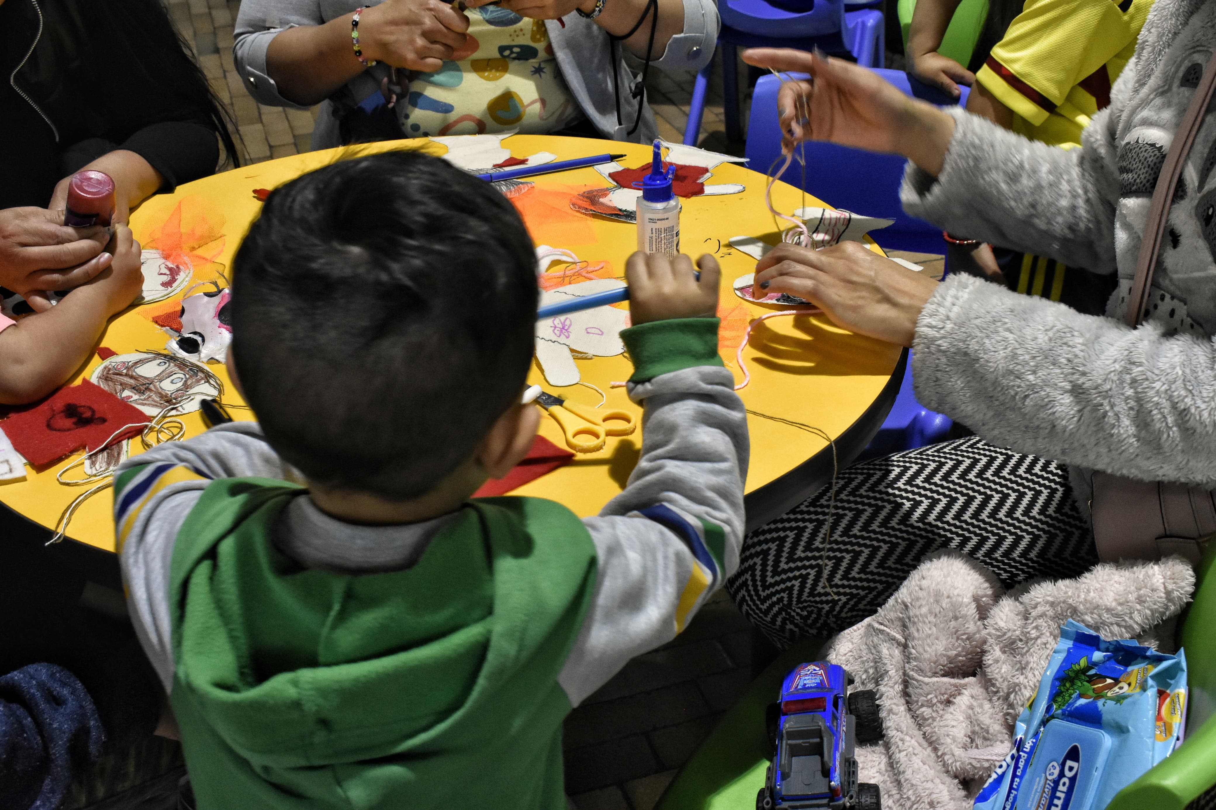 un niño en medio de un taller de manualidades 