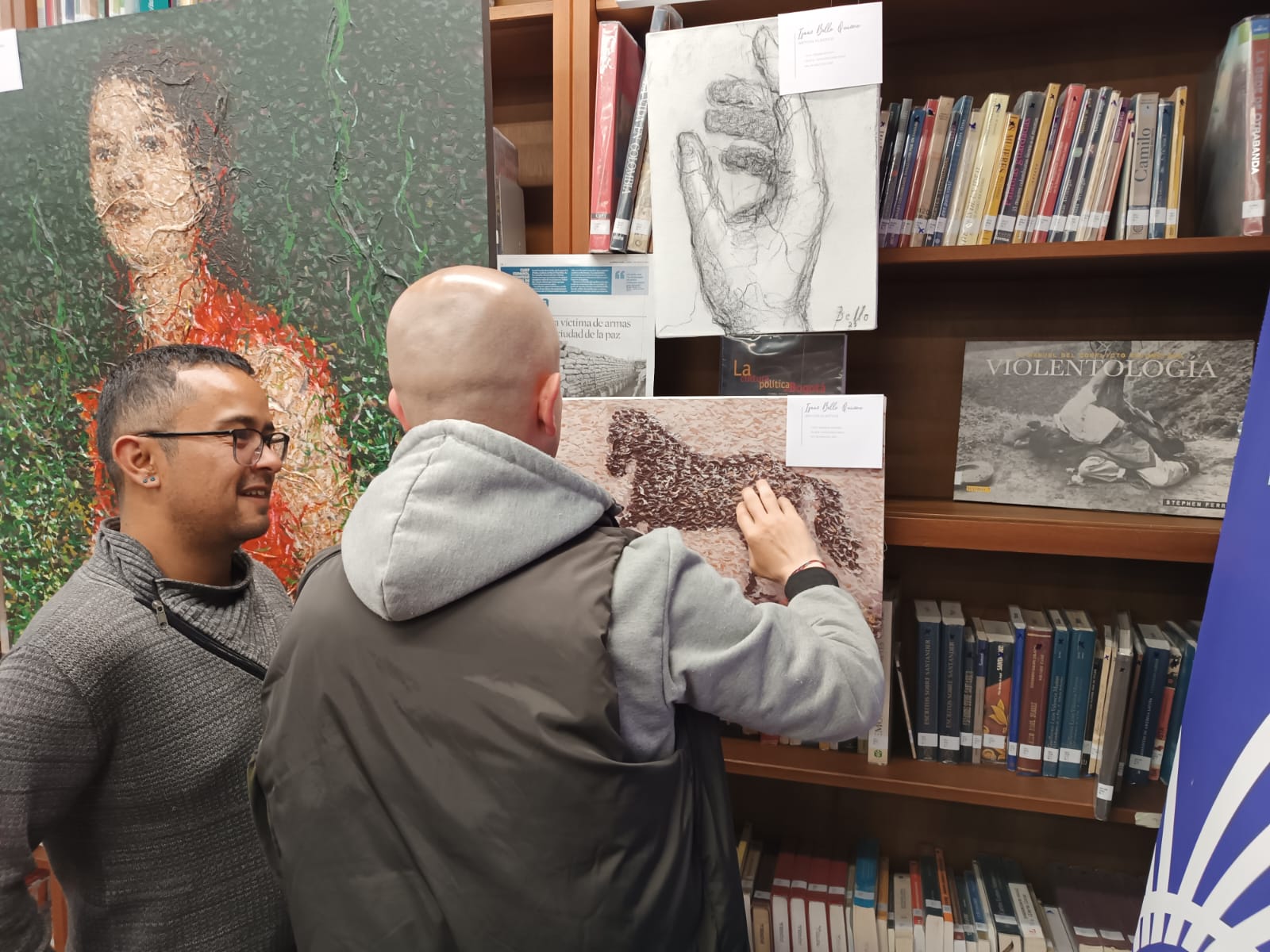 dos hombres observando y hablando acerca de la pintura que están viendo