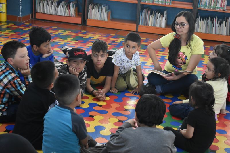 Infancias participando en el club de lectura infantil en la biblioteca