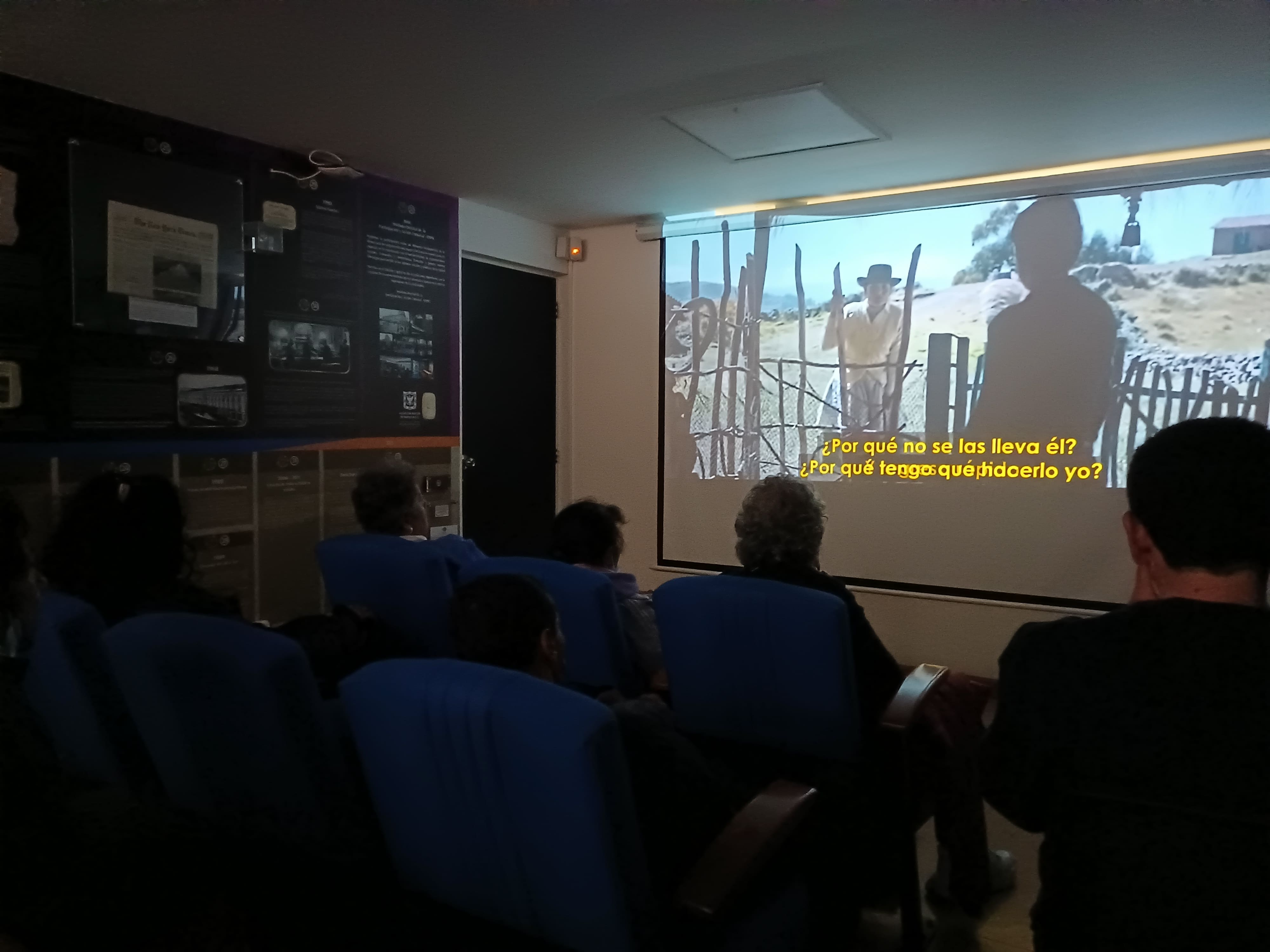 Usuarios en la sala de la biblioteca observando una proyección cinematográfica