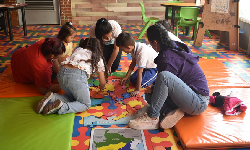 niños jugando y hablando con la docente