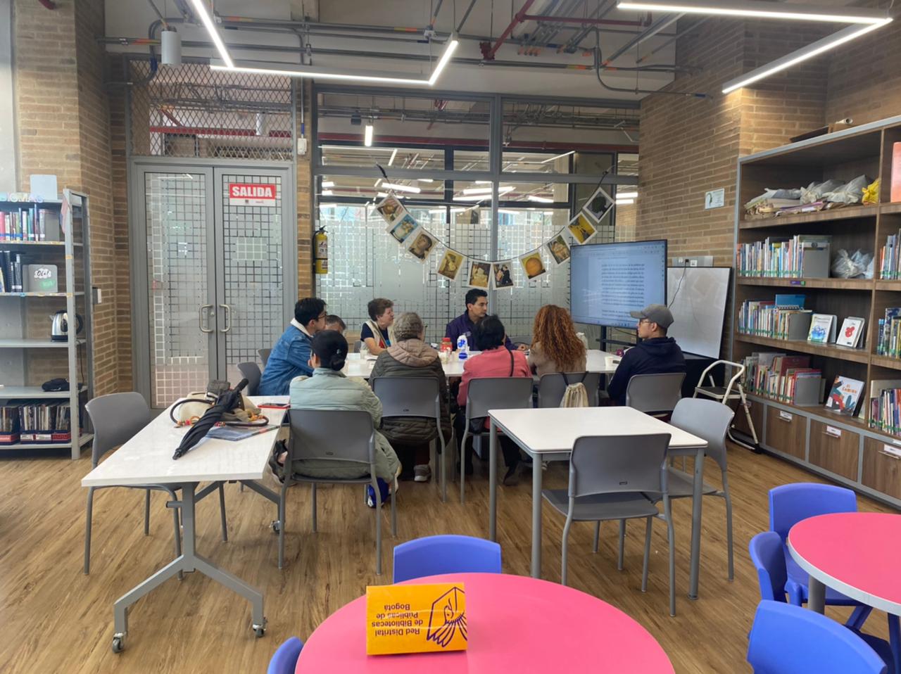 Personas participando en el club de lectura de la biblioteca