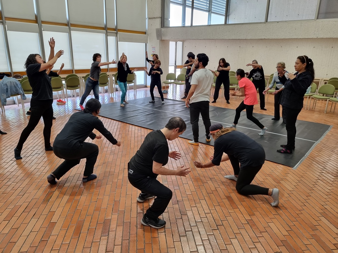 grupo de personas vestidas de negro en medio de un taller de teatro 