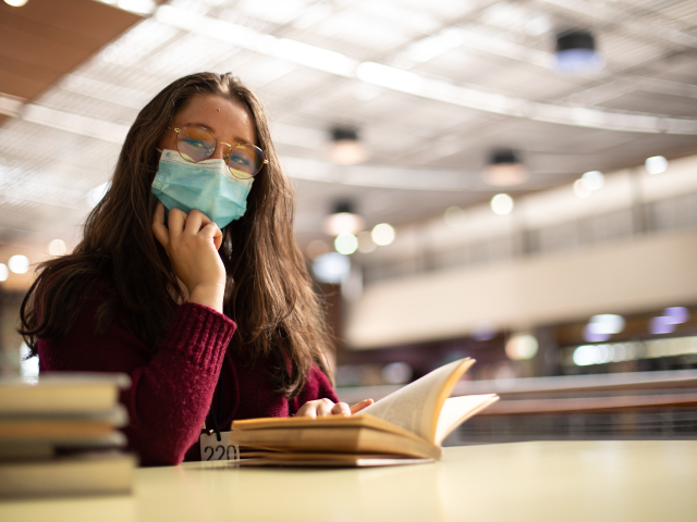 Usuaria leyendo un libro en la biblioteca