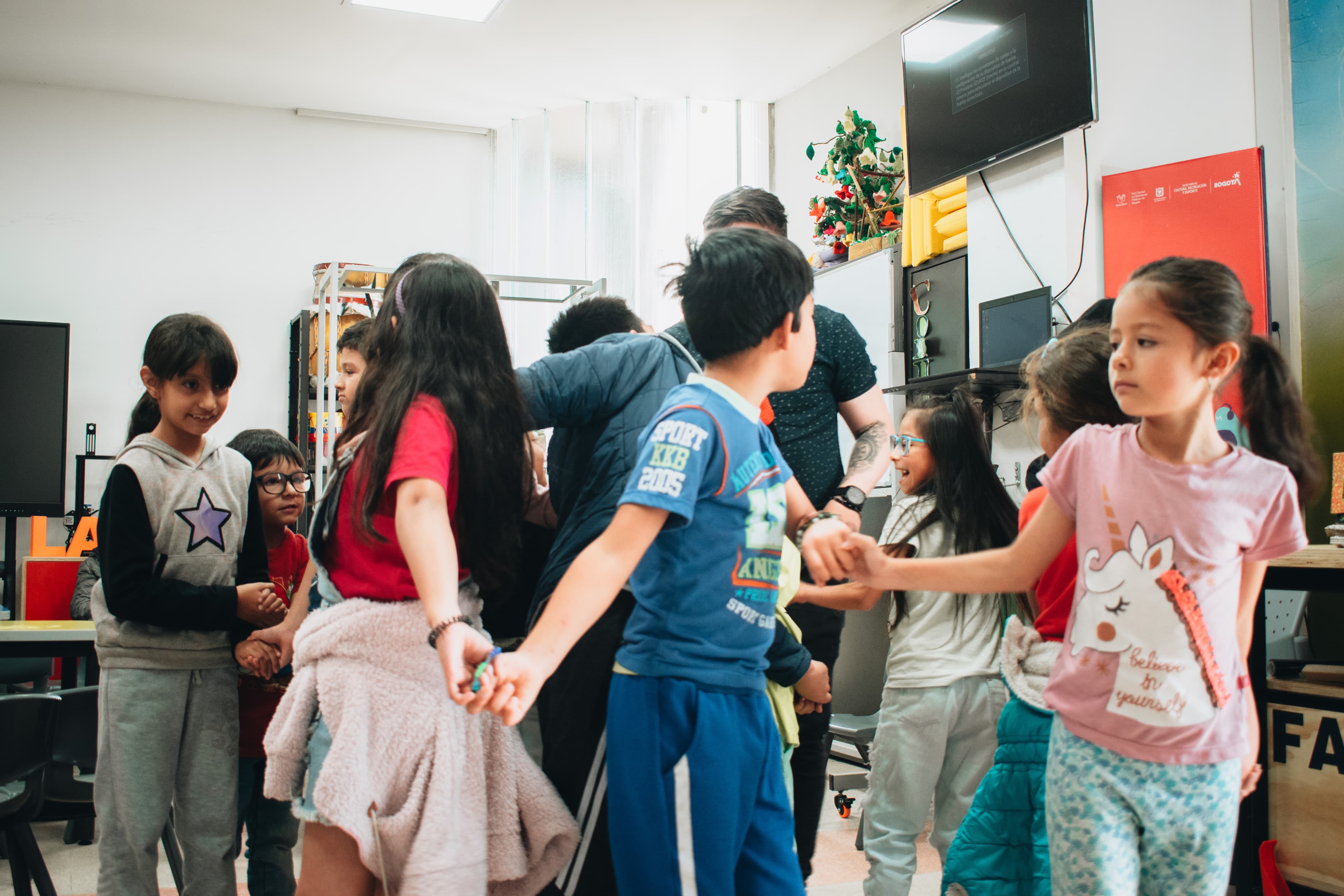 grupo de niños y niñas tomados de las manos y jugando 